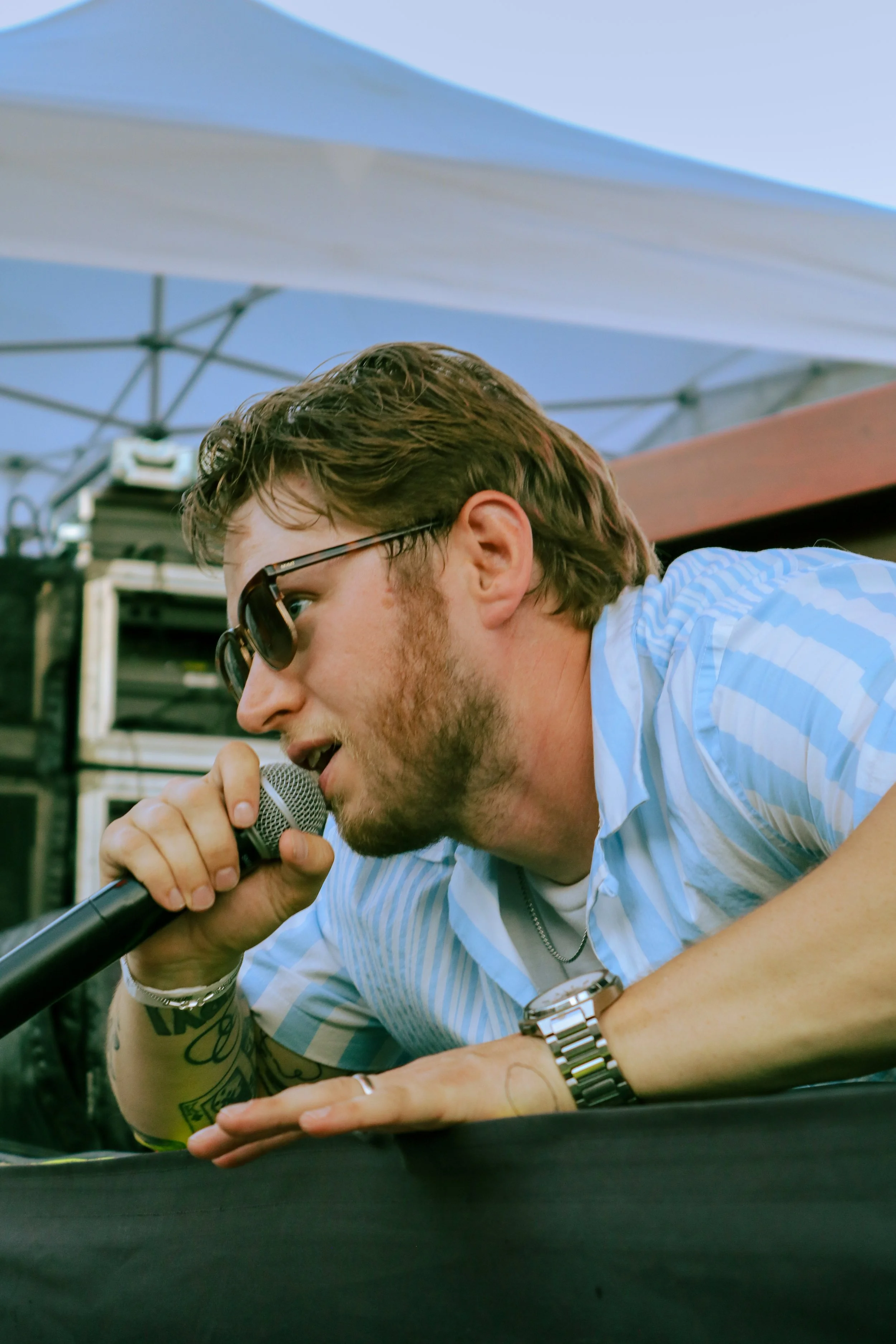 Tye of The Groove Merchants lies on stage while singing to the crowd