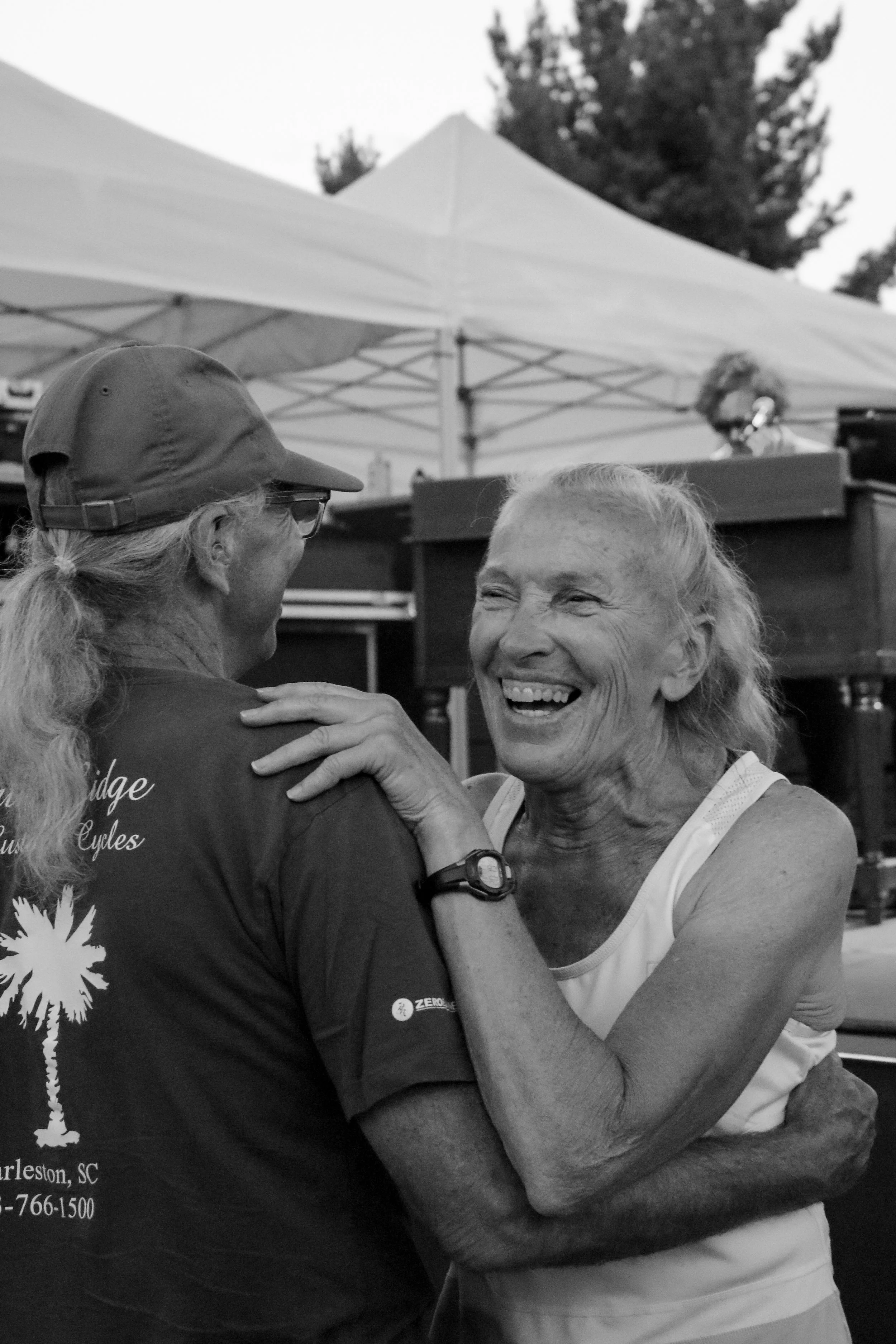 An older couple dances together during The Groove Merchants’ performance in a black-and-white photograph