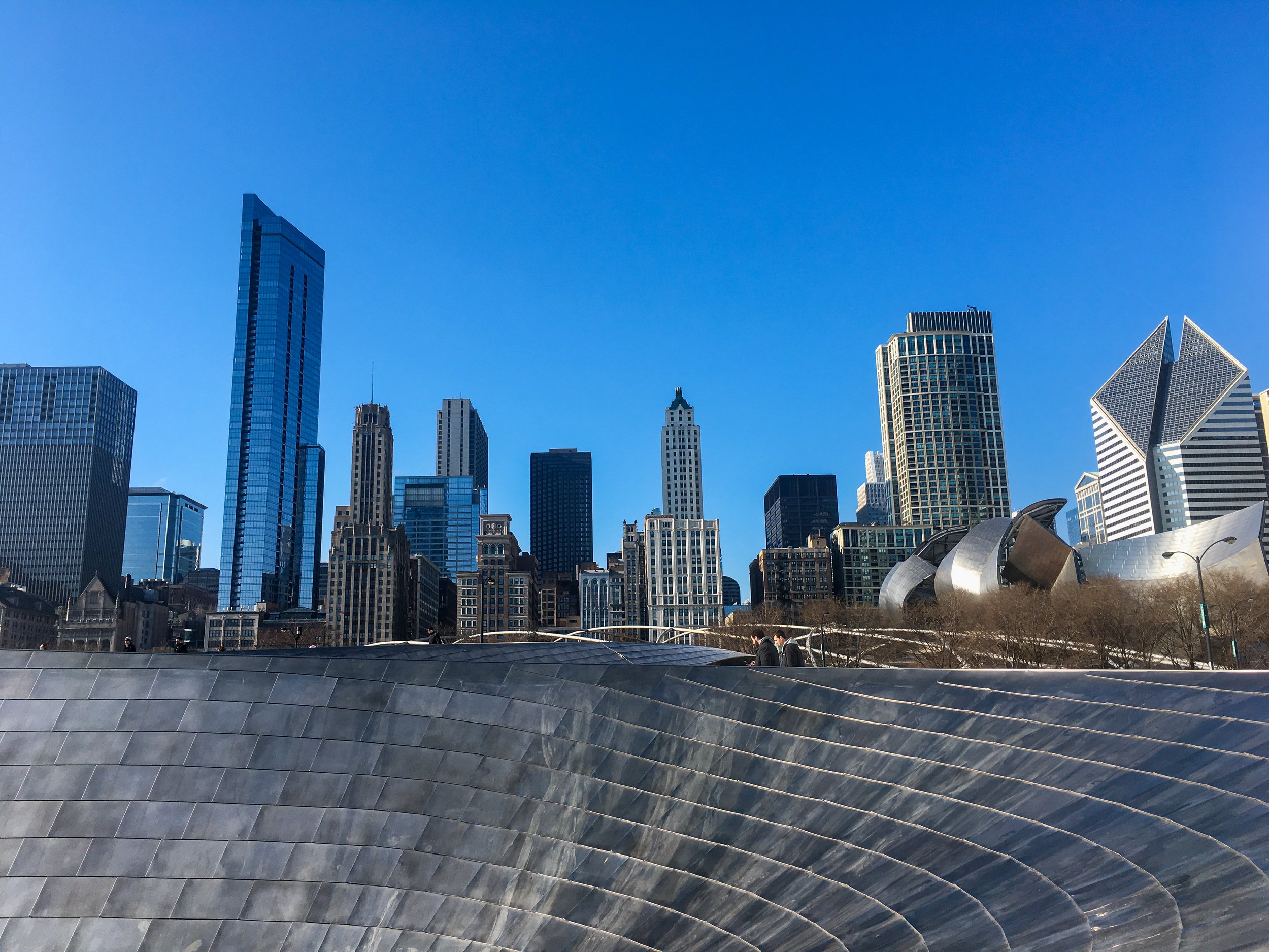 Chicago skyline viewed above Millennium Park with modern architectural structures in the foreground