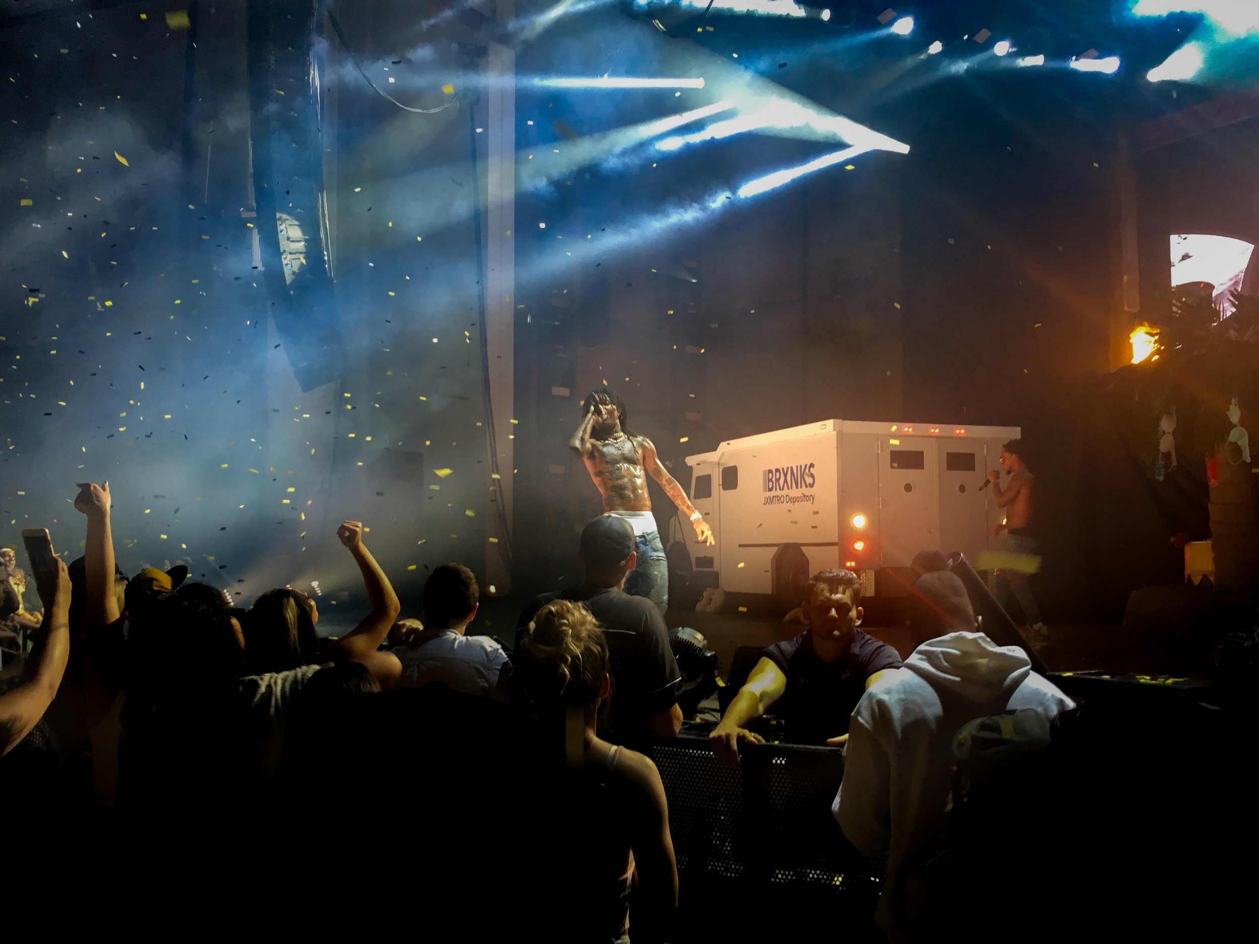 Swae Lee of Rae Sremmurd performing on stage in front of a money van with confetti falling around him