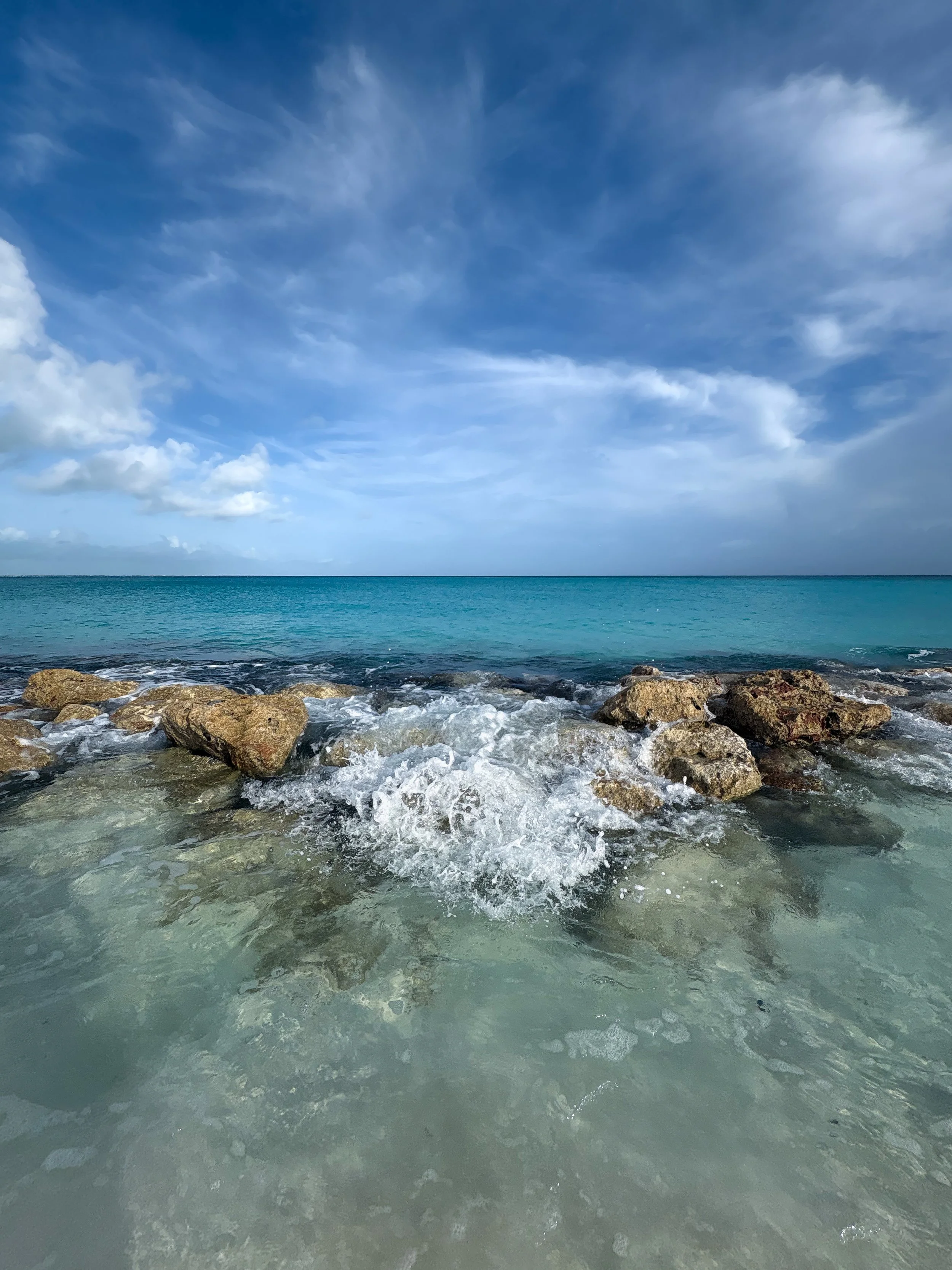 Waves crashing through rocks in the Caribbean blue waters of Turks and Caicos