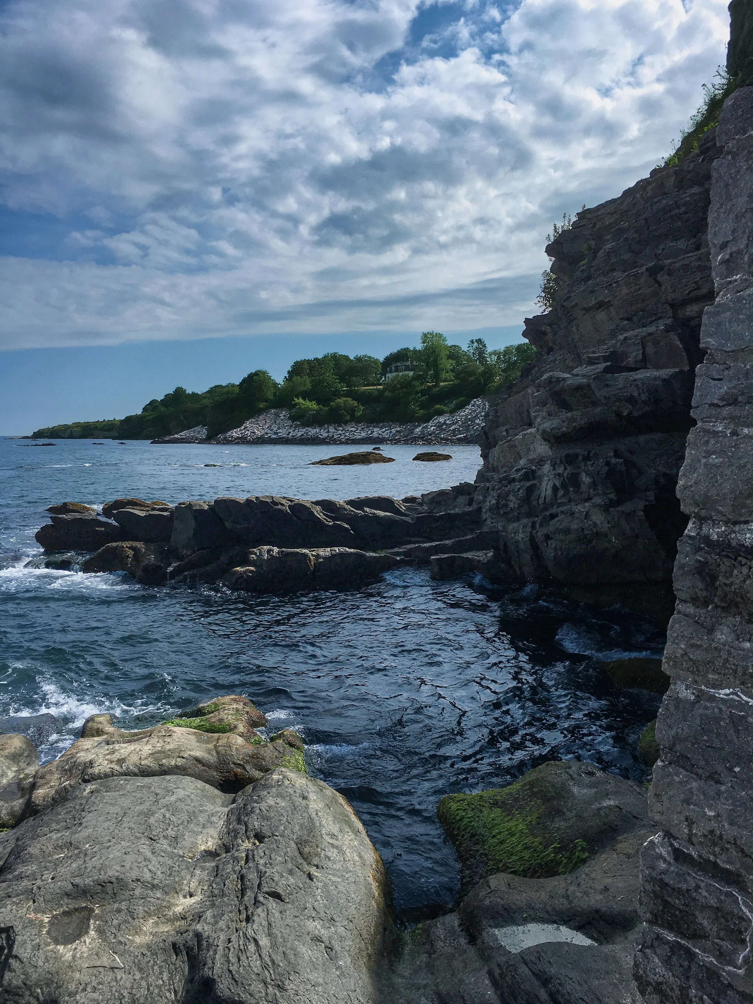 Calm ocean water meeting rocky shoreline along the coast of Rhode Island