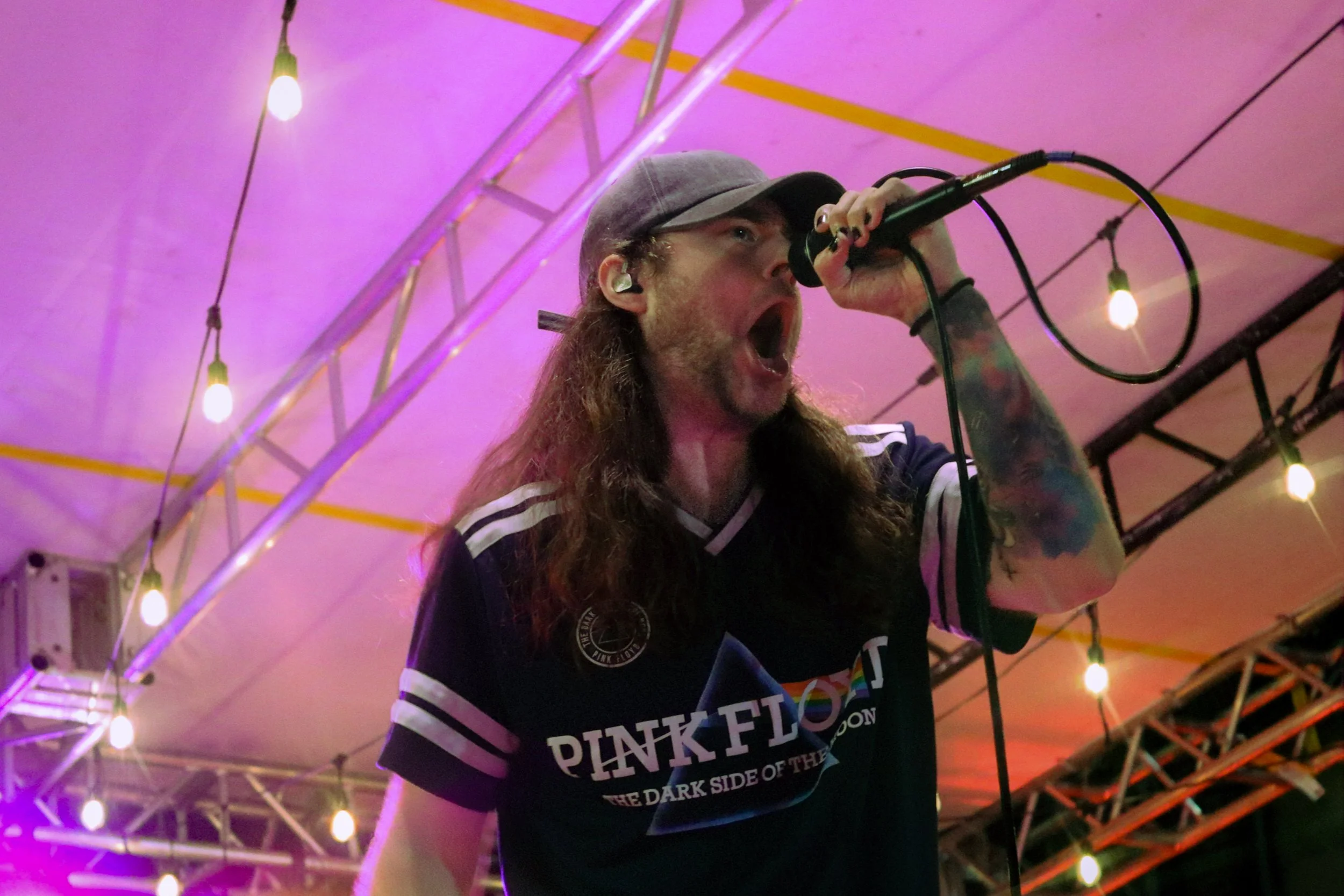 Dakota of Another Day Dawns sings into a microphone during a live performance