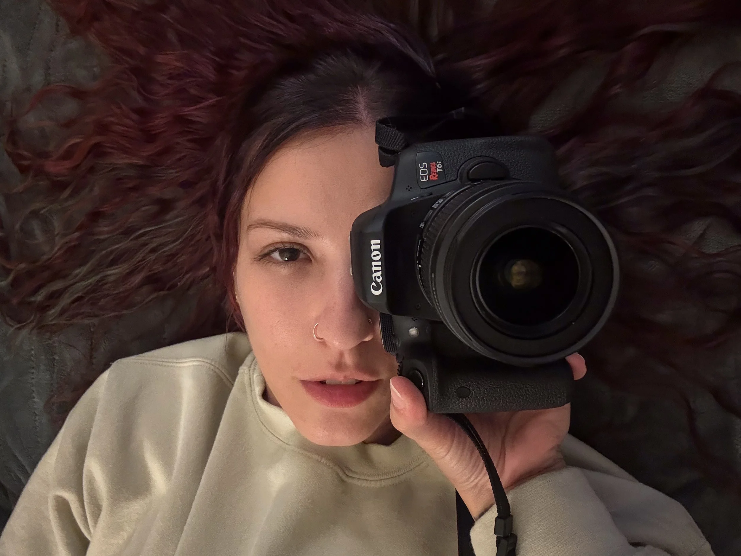 Photographer Madison Malik holding a camera in front of her face