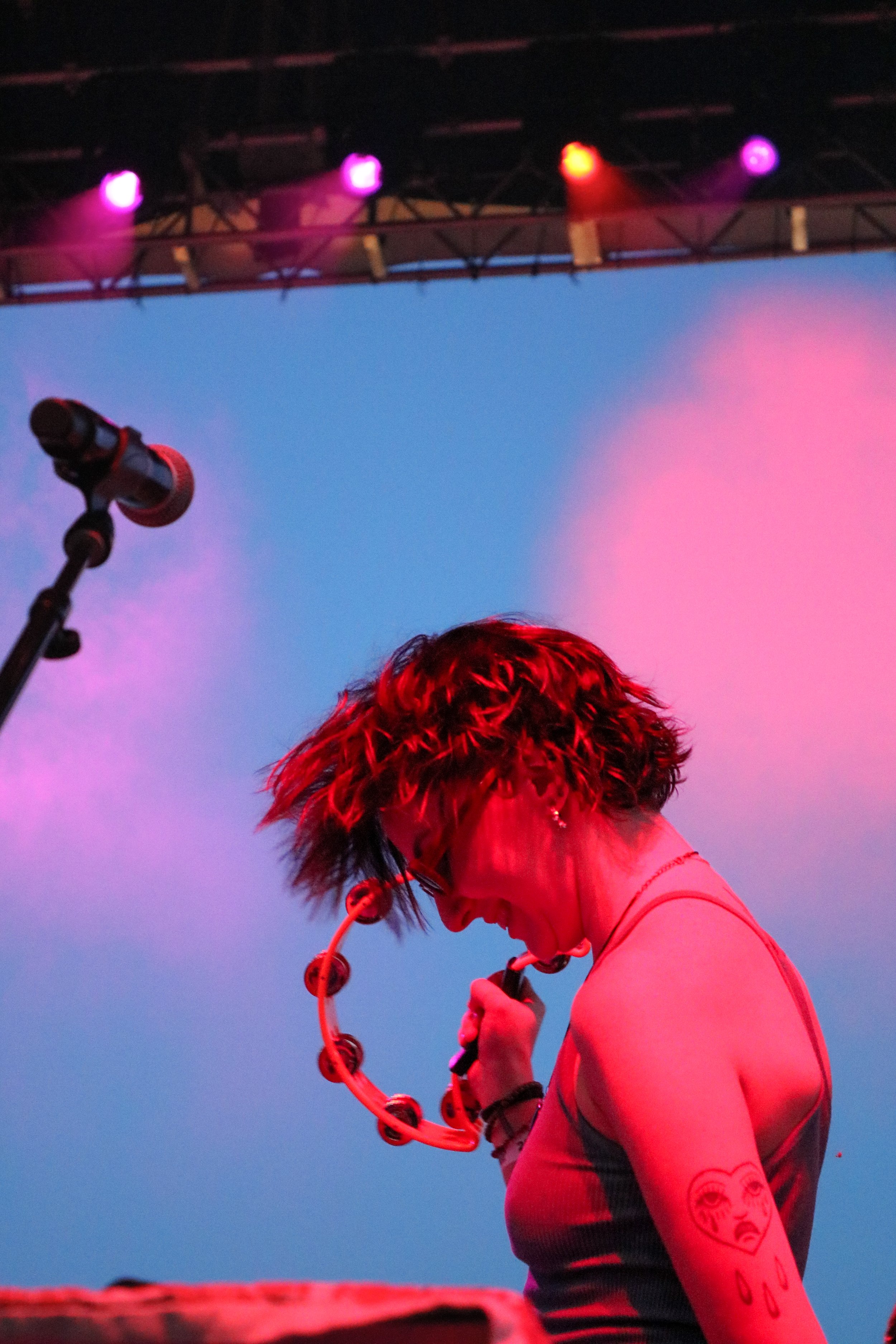 A member of The Groove Merchants plays the tambourine during a live performance