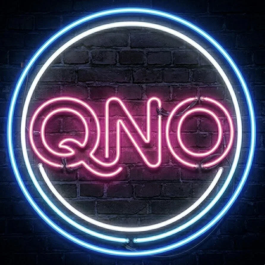 Neon sign reading 'QNO' in pink inside a large blue circle on a black brick wall.
