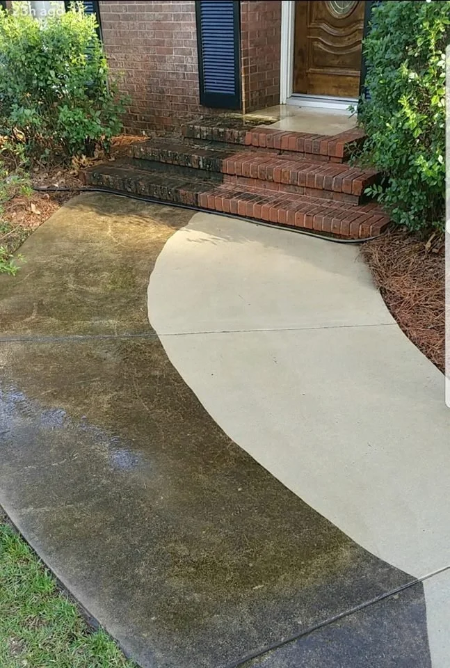 A front porch with brick steps leading to a wooden door, and a concrete walkway being pressure washed