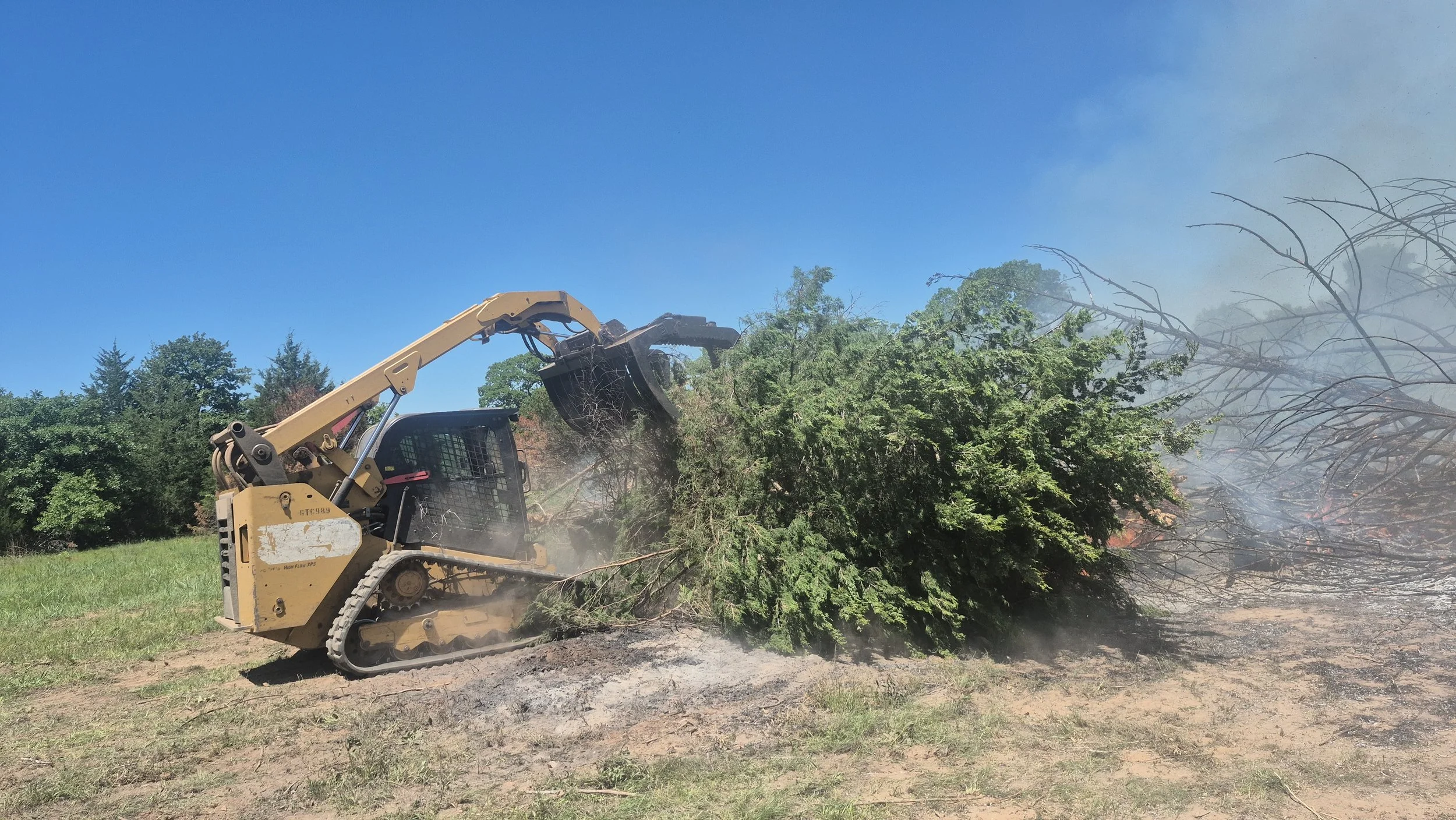 Our 299D moving a pile of cedar trees to our designated burn site