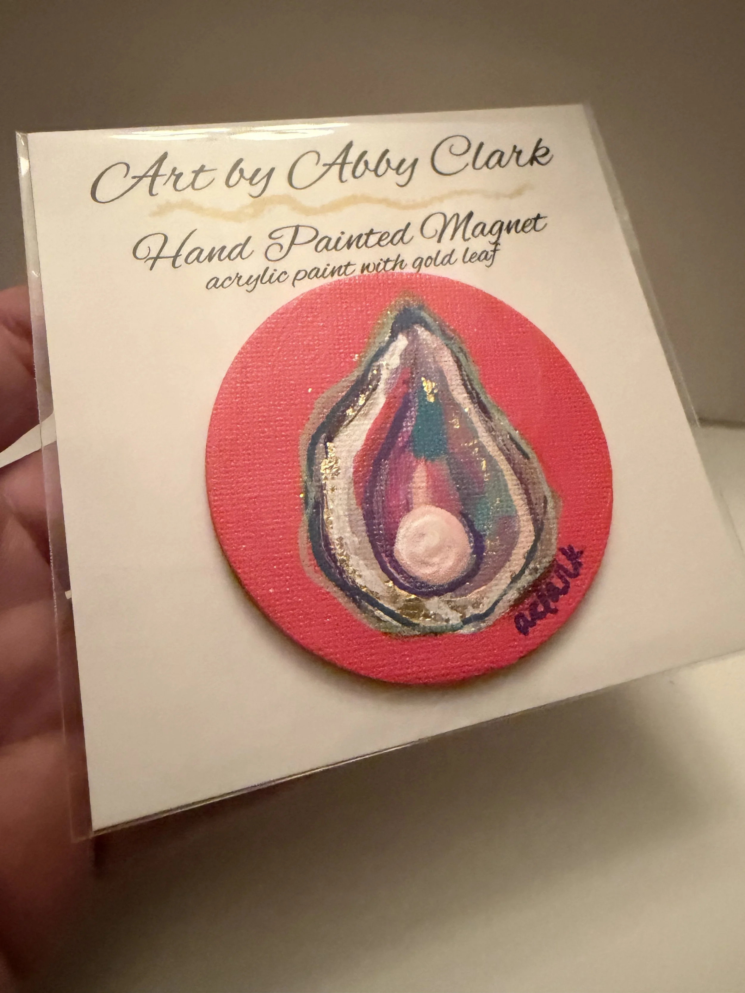Angled view of the round oyster magnet, showing the painted oyster and raised pearl embellishment