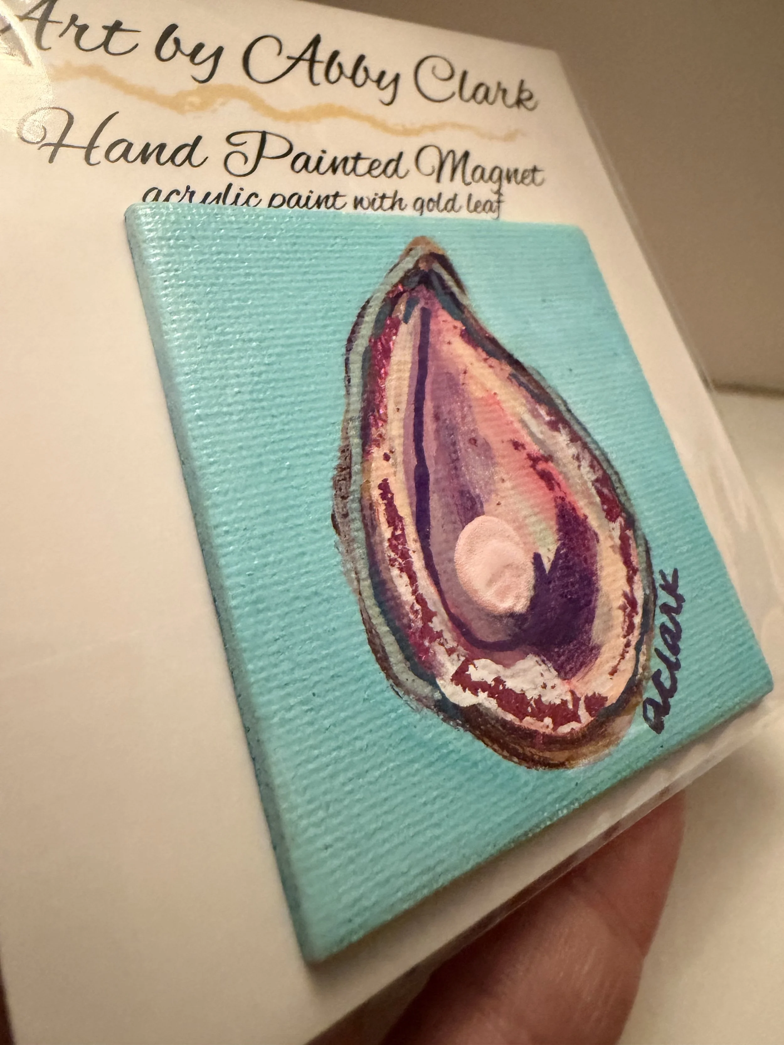 Closer view of the turquoise oyster magnet in clear packaging