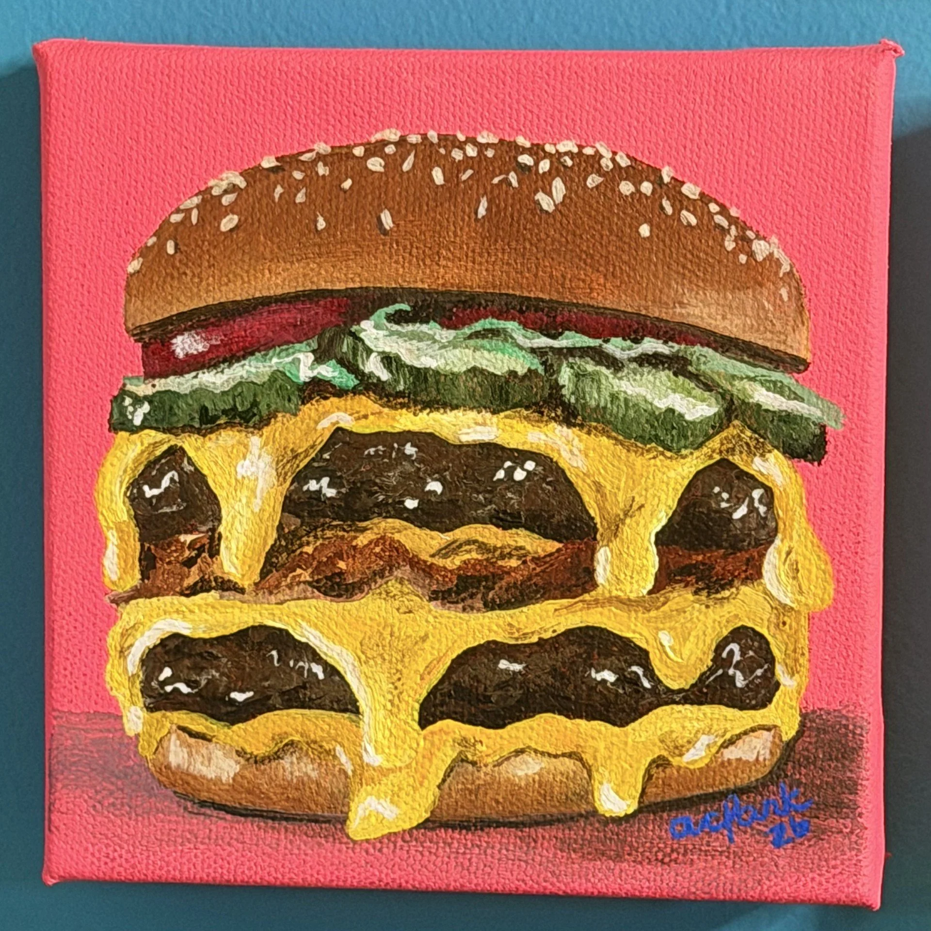 The Big Cheese mini painting of a cheeseburger with melted cheese, pickles, and a sesame-seed bun on pink