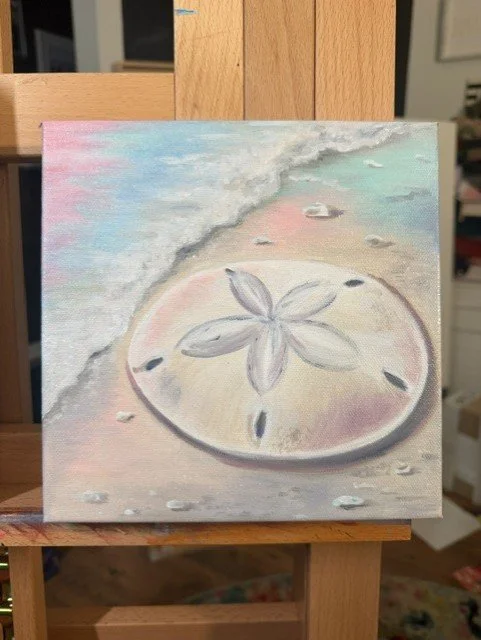 Sand dollar painting on a softly colored shoreline by Abby Clark