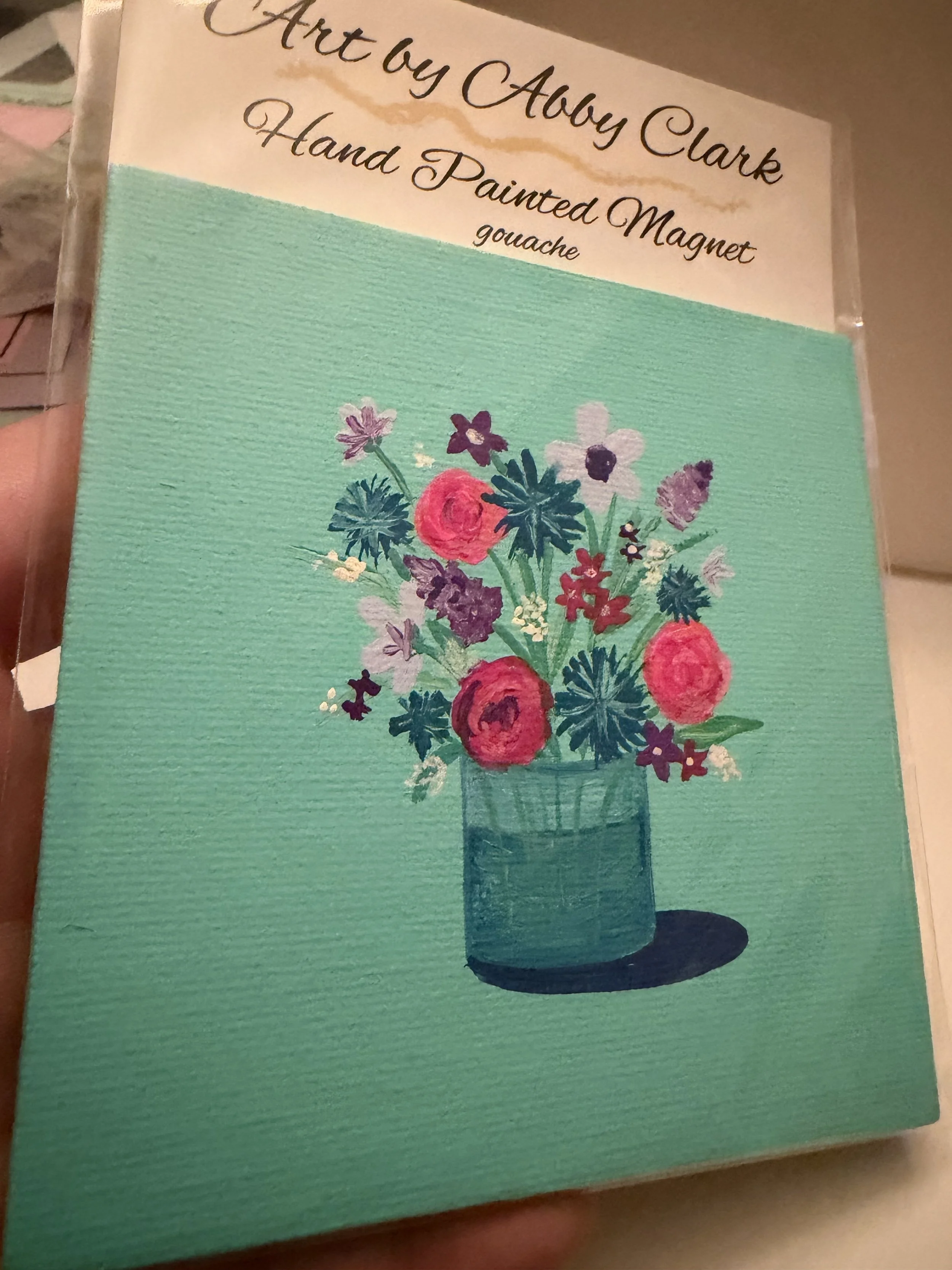 Closer angled view of the hand-painted Floral Bouquet magnet against its turquoise background