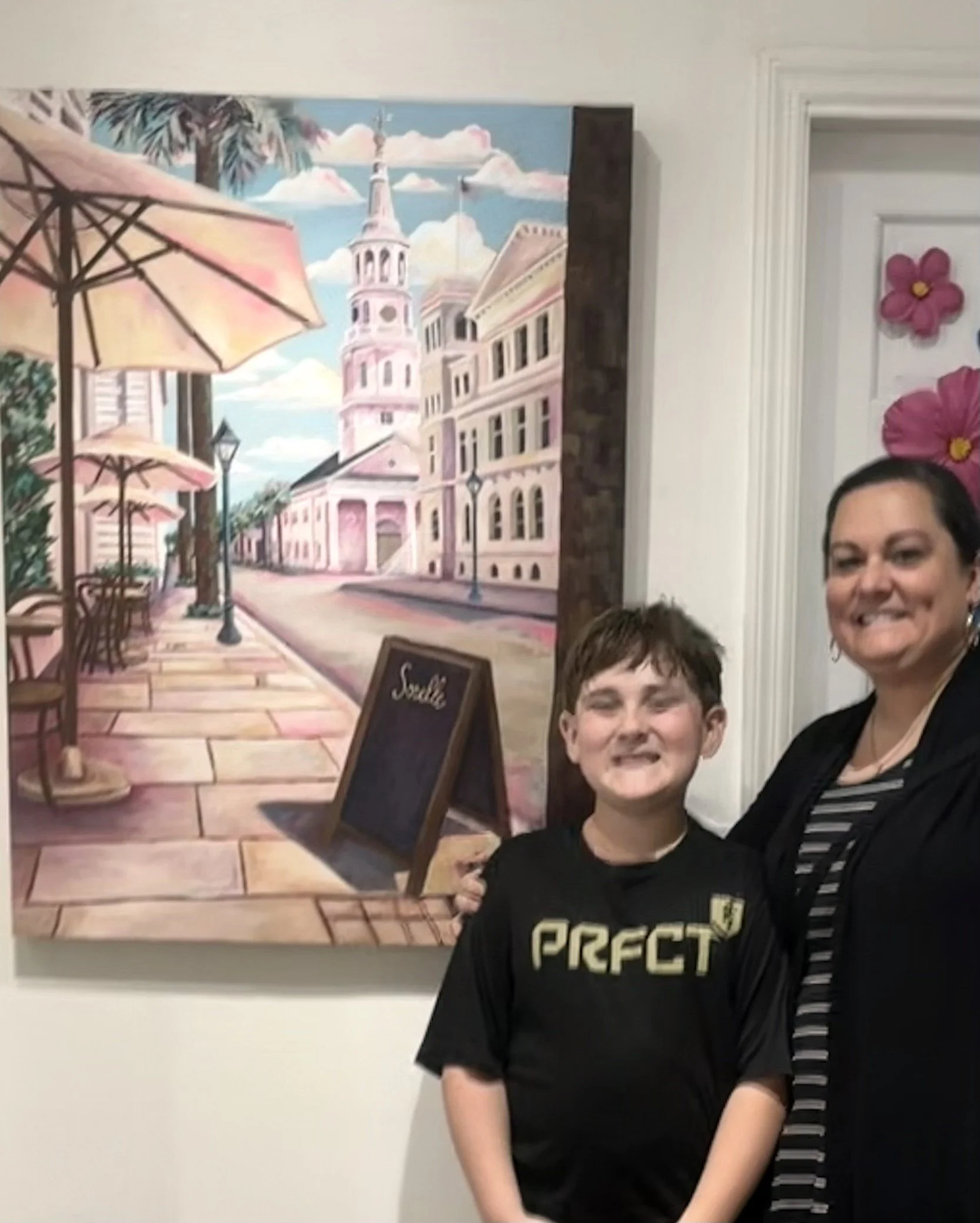 Abby Clark beside her colorful Charleston street painting in her studio