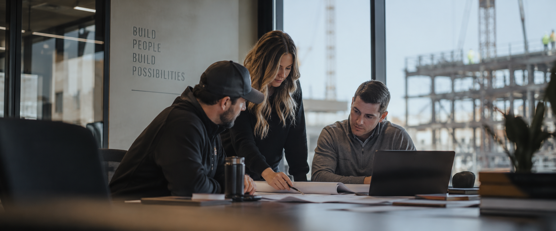 ARB Employees working together for success -- three people at a table reviewing plans