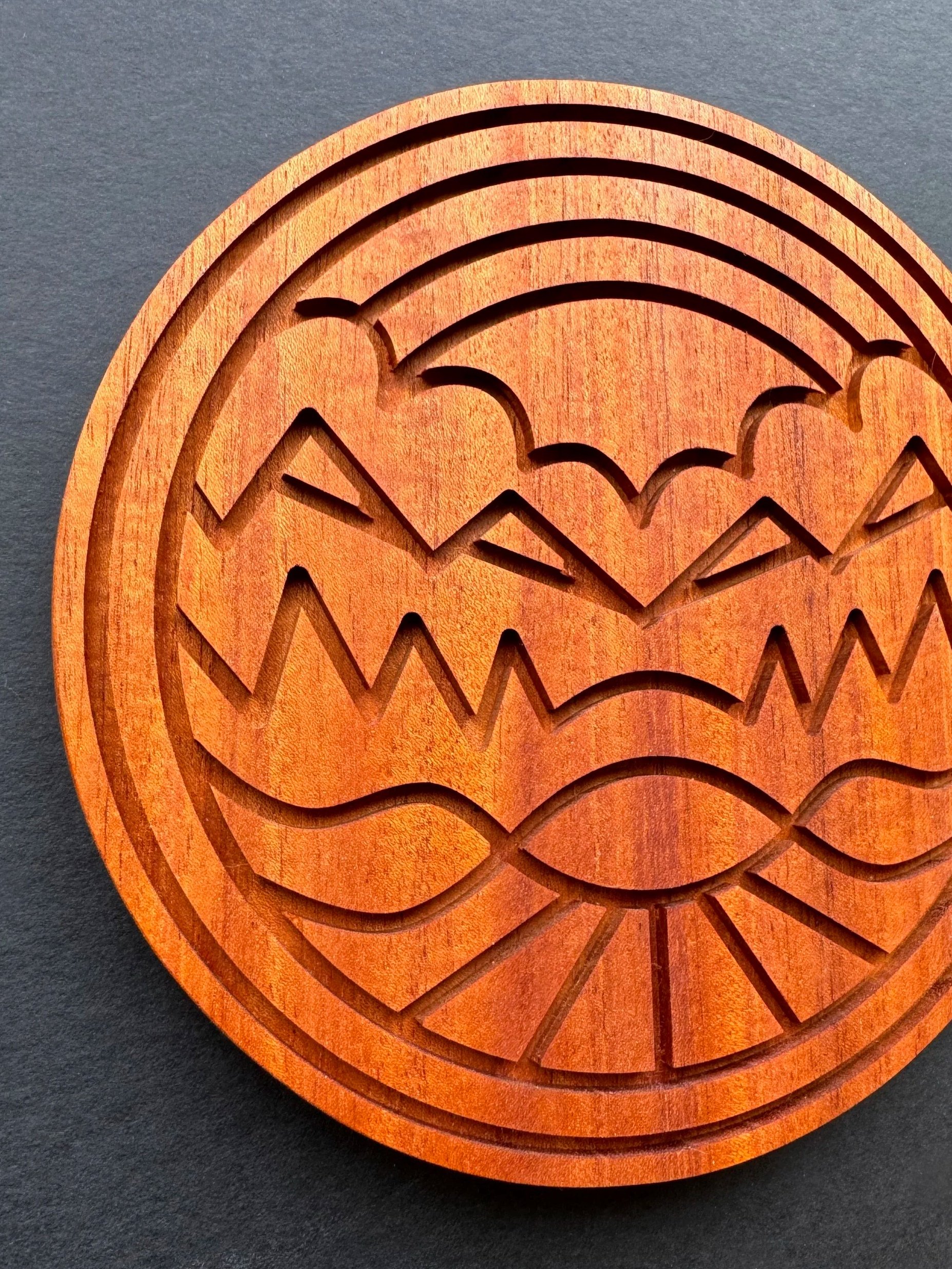 Wooden, carved surface with mountain to sky graphic visual treatment