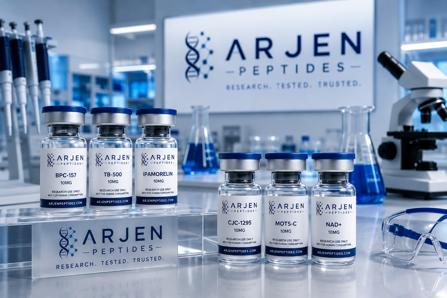 Vials of research peptides labeled ARJEN PEPTIDES arranged on a lab bench in a laboratory with laboratory equipment and a sign reading ARJEN PEPTIDES - RESEARCH. TESTED. TRUSTED.