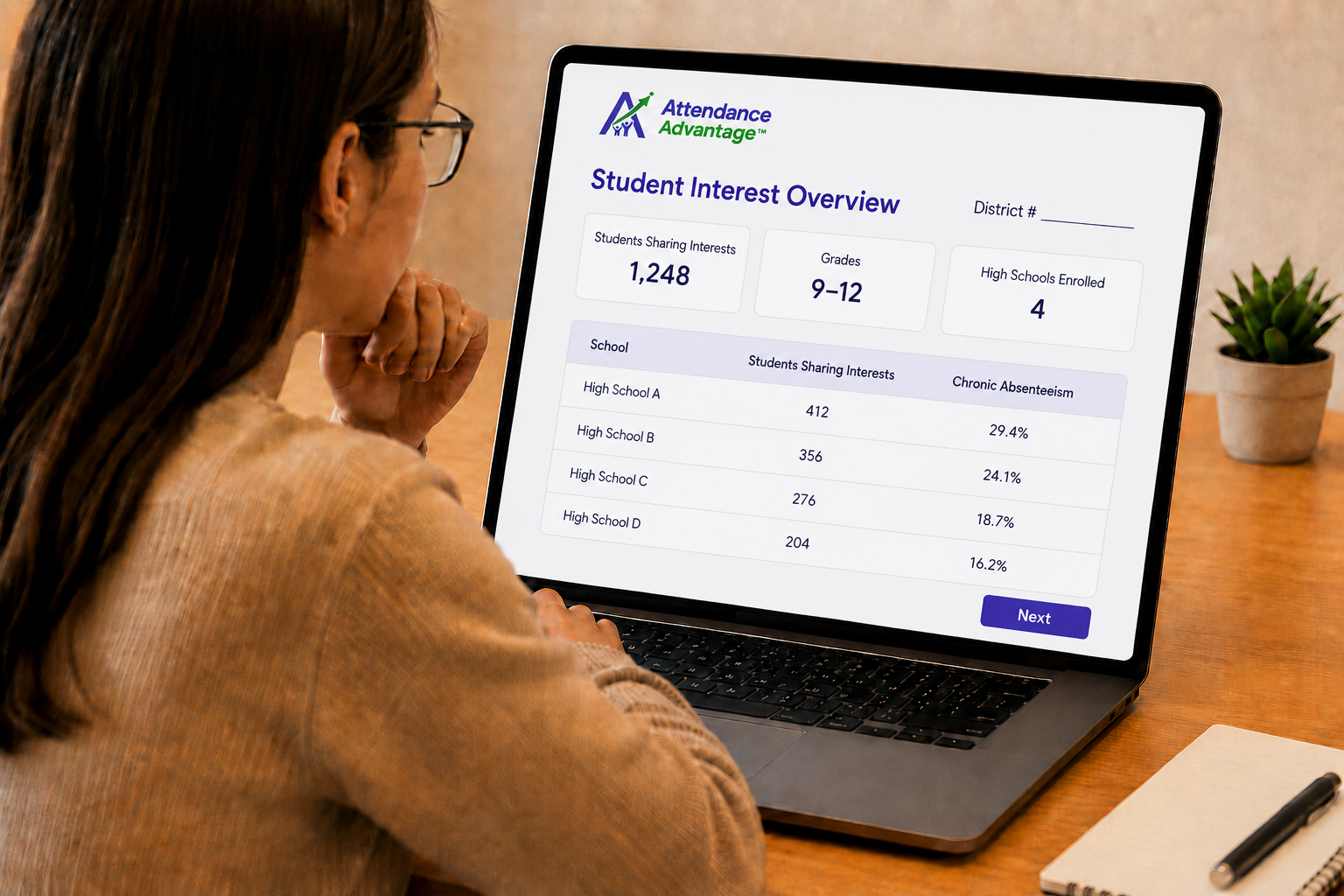 Woman reviewing student data on laptop.