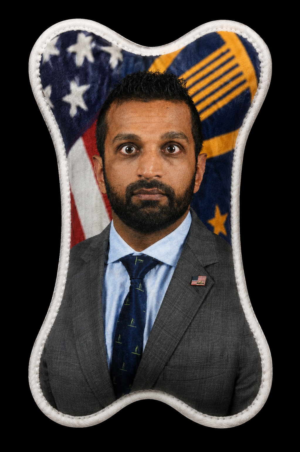 Kash Patel wearing a grey suit, light blue shirt, and navy tie with small yellow designs, in front of an American flag.