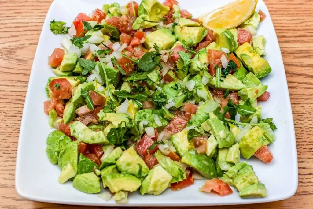Fresh avocado salad with tomatoes, onions, cucumbers and light seasoning