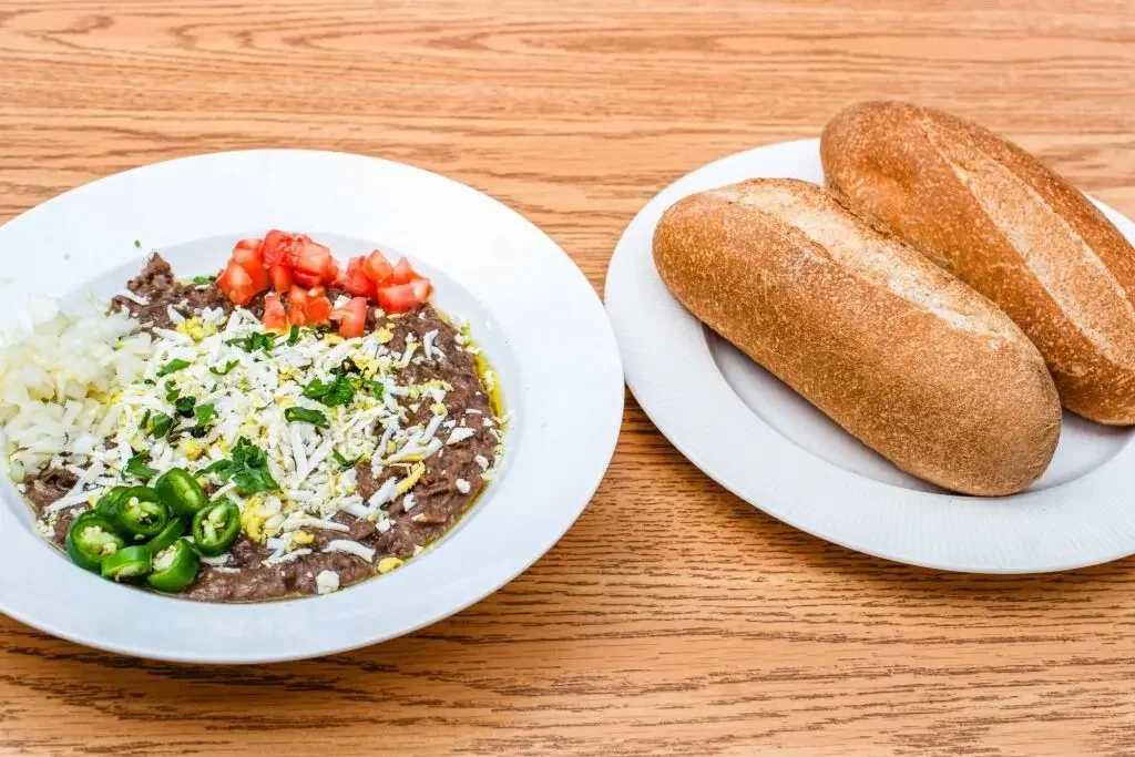 Traditional Habesha foul meselah with fava beans, vegetables, boiled egg, herbs and fresh bread