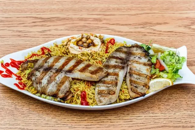 Grilled tilapia seasoned with ginger, garlic, onions and black pepper served with rice or fries