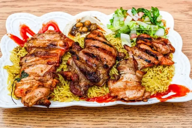 Juicy grilled chicken thighs marinated with paprika and lemon served with rice or fries