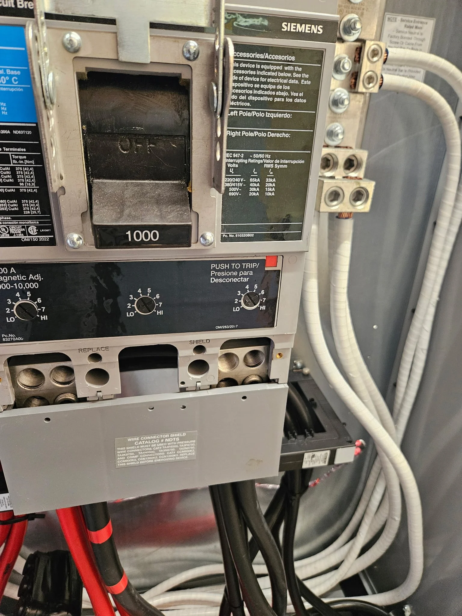 Close-up of an electrical control panel with labeled wires and switches, including a black switch cover with 'OFF' text, and various cables connected to the panel.