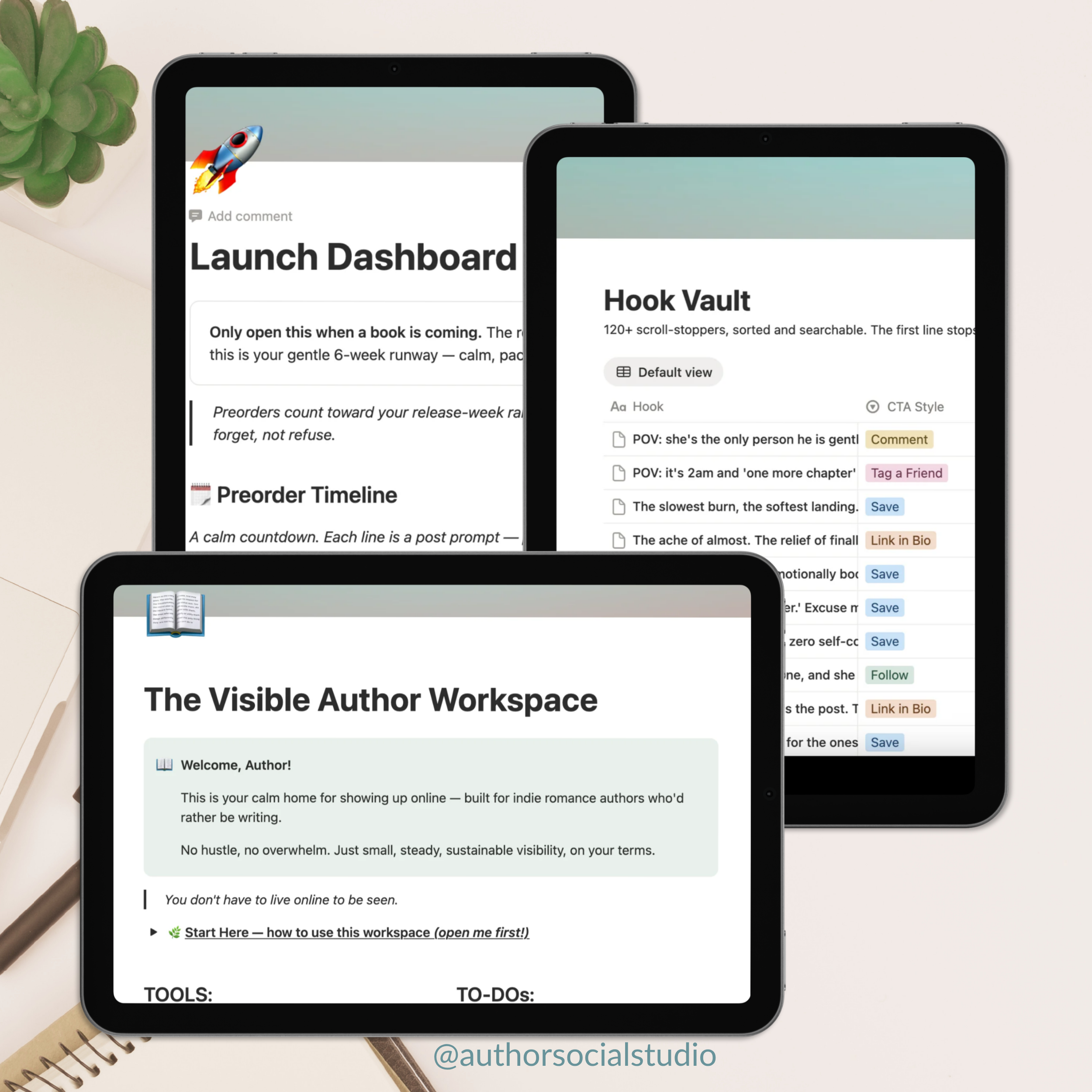 sample pages of The Visible Author Workspace for Notion displayed on iPads, laying flat on a white desk with a notebook and a green plant