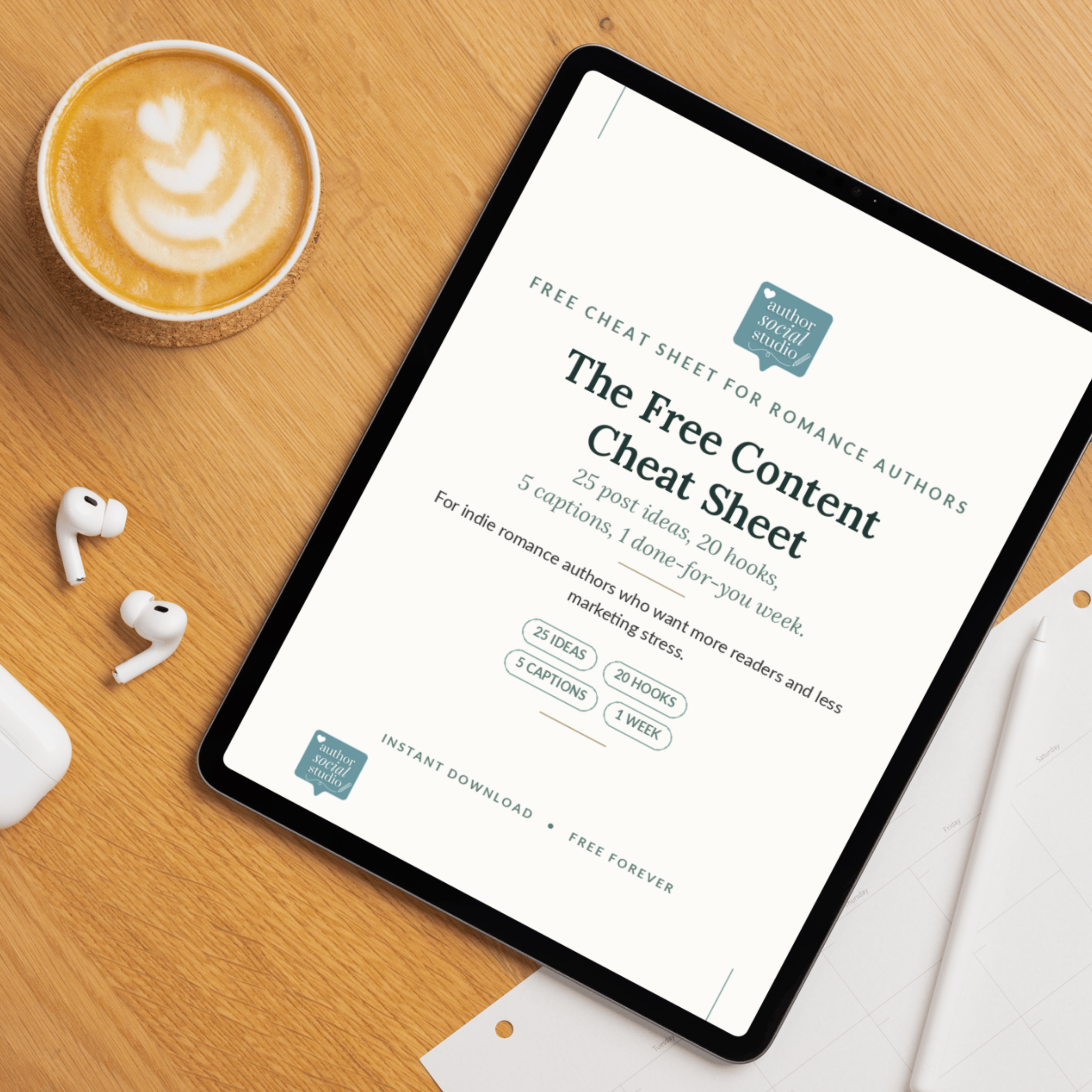 A wooden desk with a cup of coffee with latte art, a smartphone displaying a webpage titled 'The Free Cheat Sheet,' and a pair of white wireless earbuds.
