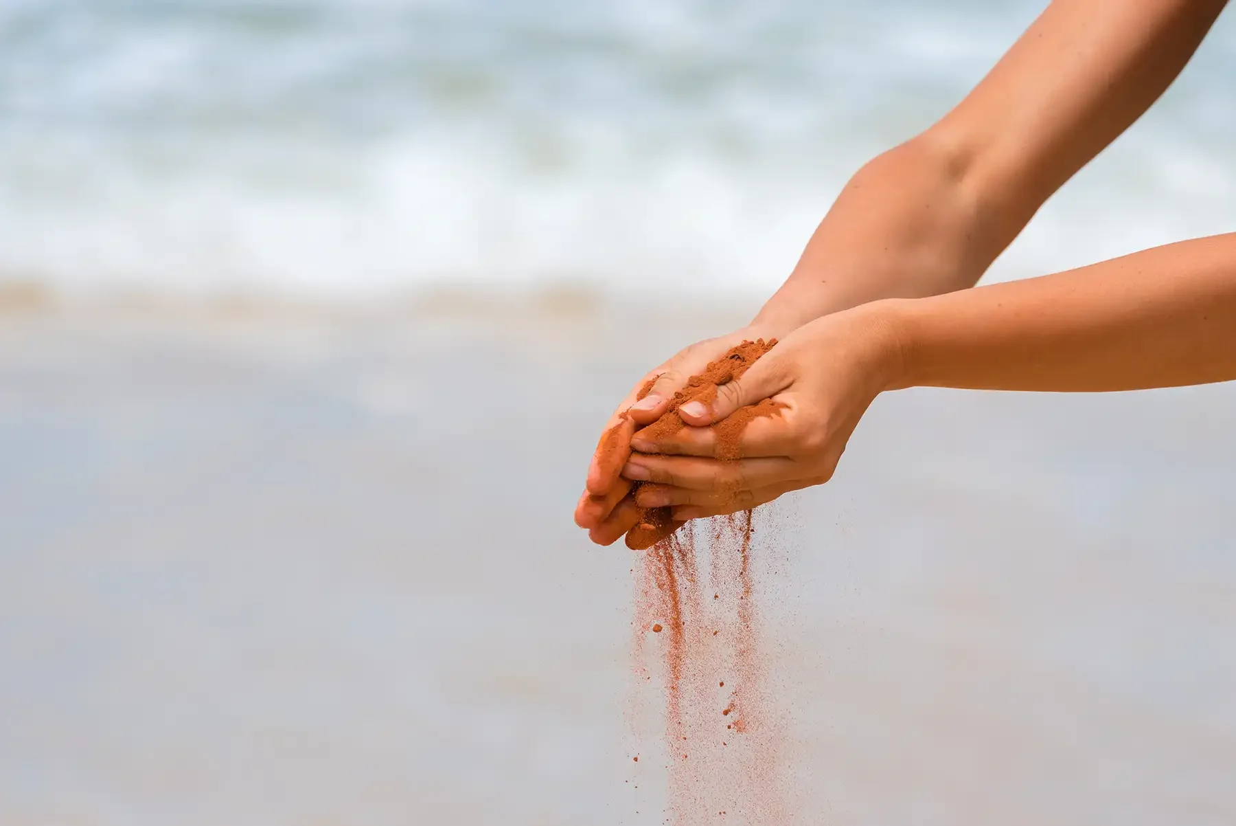 red sand running through hands