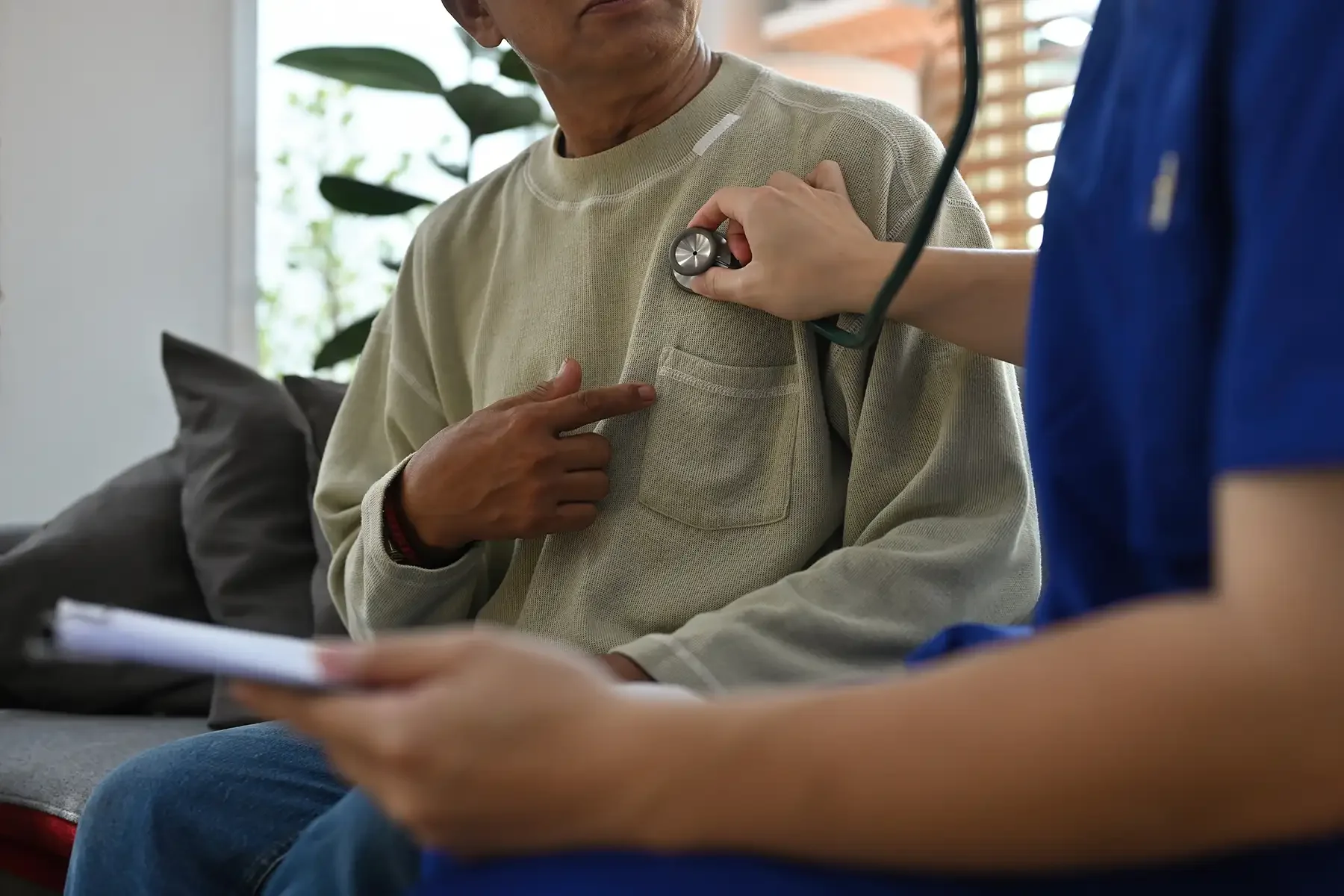 a doctor holding a stethoscope to a persons chest