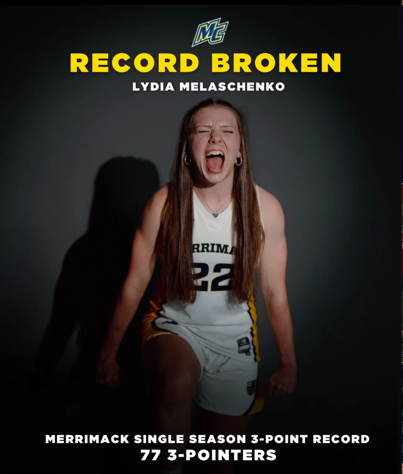 A young female basketball player wearing a Merrimack College jersey, yelling excitedly. Text on the image reads: 'Record Broken Lydia Melashenko. Merrimack single season 3-point record, 77 3-pointers.'