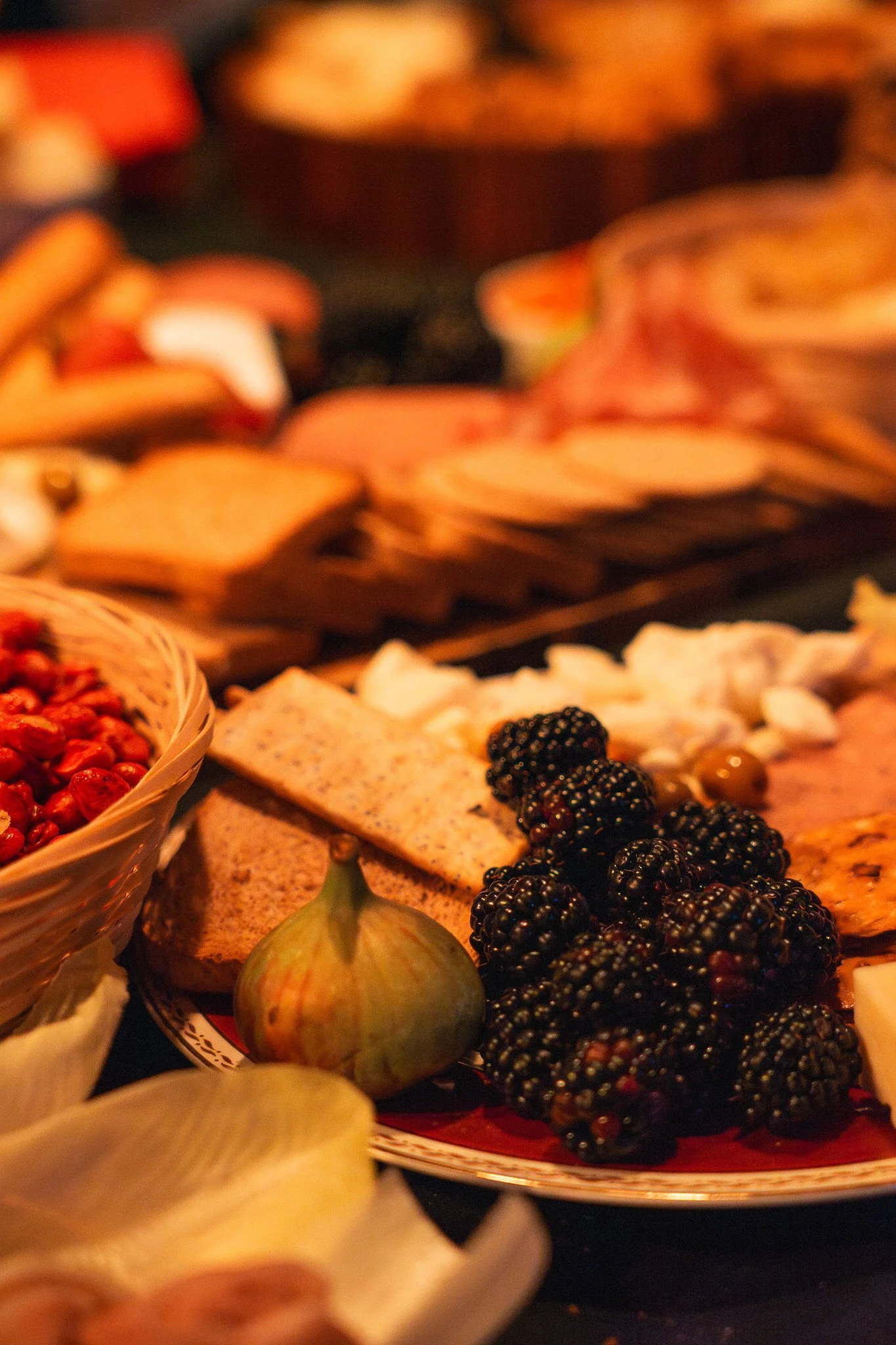 Plate avec des figues, mûres, fromage, crackers et un dessus d'oignon vert.