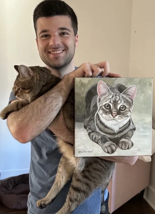 Man holding cat and cat's portrait.