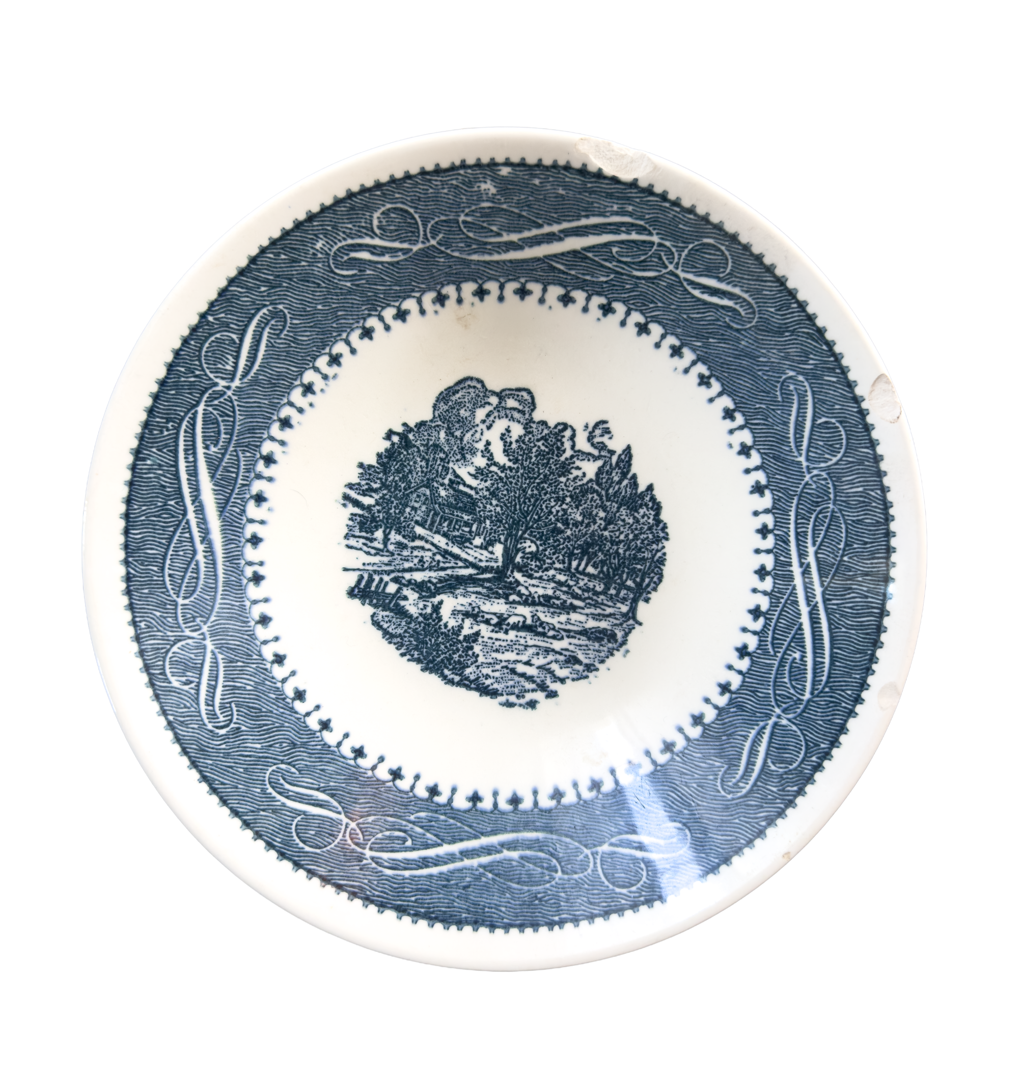 Close-up of a vintage blue and white ceramic plate with intricate floral and geometric designs.