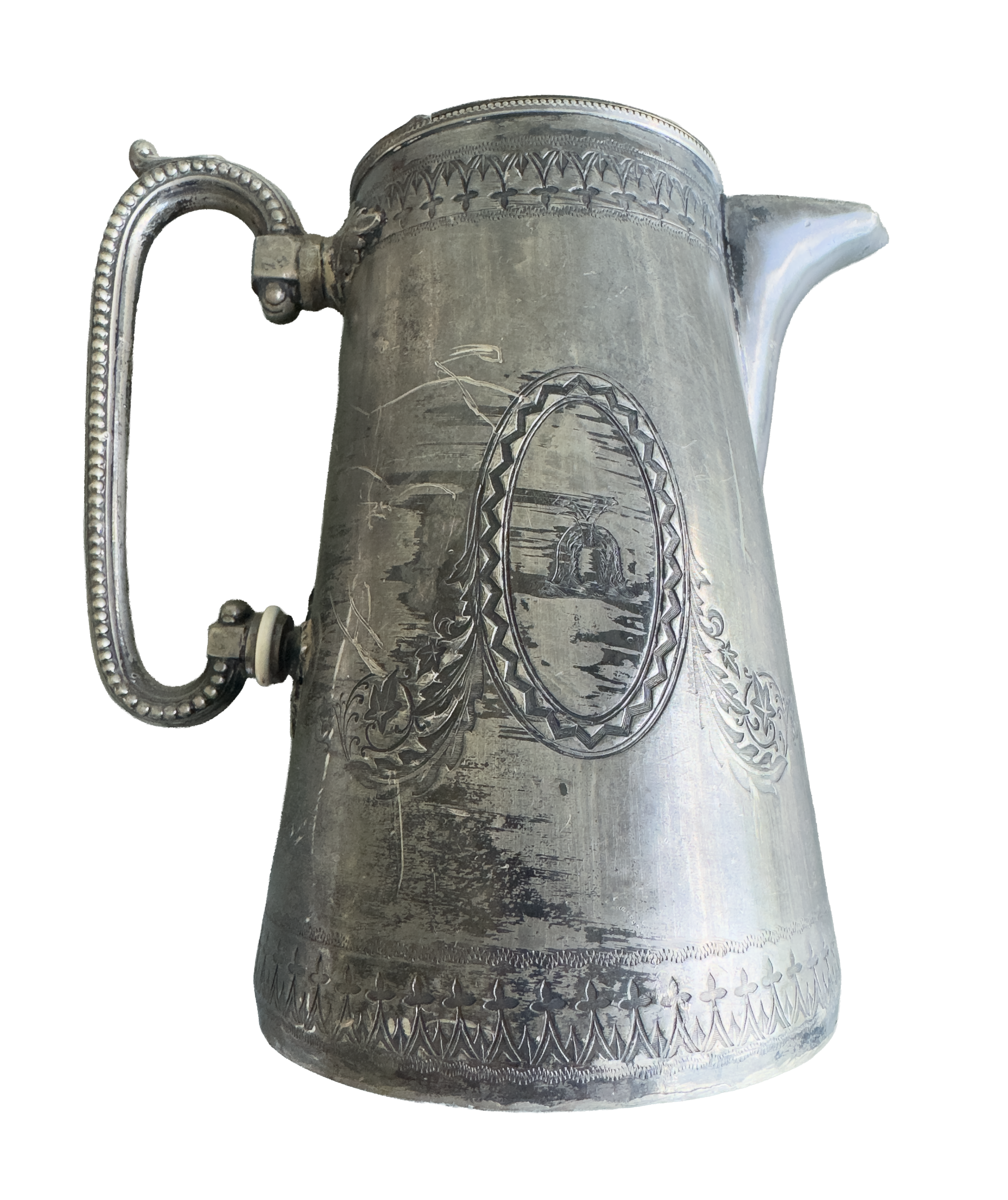 An old silver tankard with intricate engraved patterns around the top, handle, and lower part, featuring floral and geometric designs.