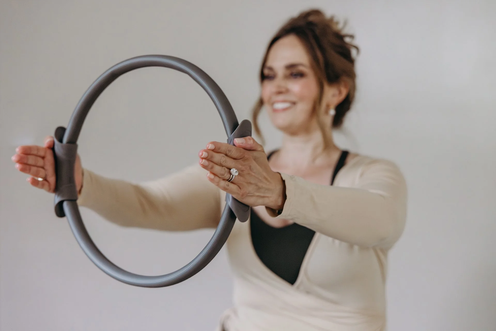 Woman using a Pilates ring for an upper-body exercise at Liro Pilates in Anchorage, Alaska