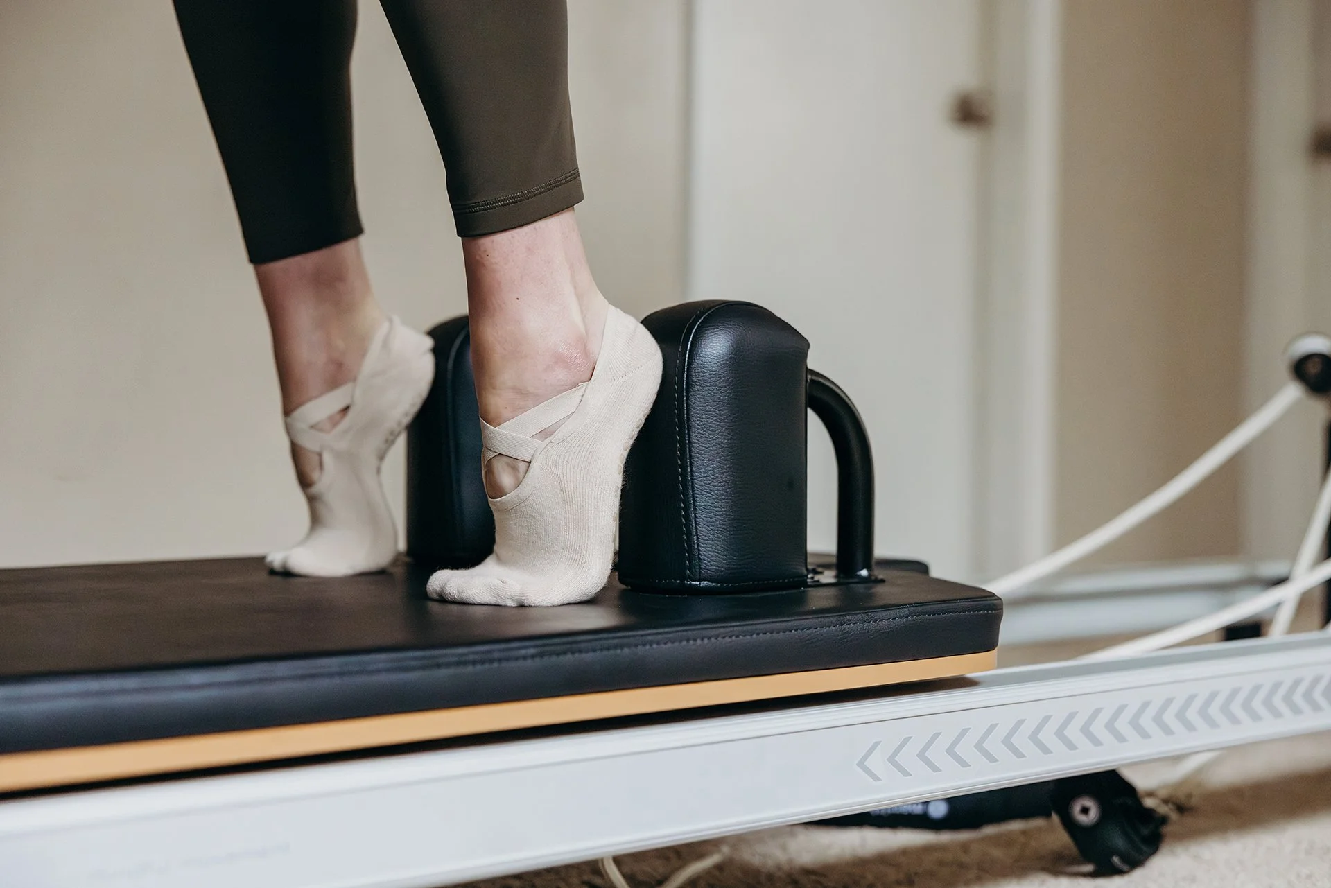Close-up of a client’s feet in grip socks during a standing reformer exercise at Liro Pilates in Anchorage, Alaska