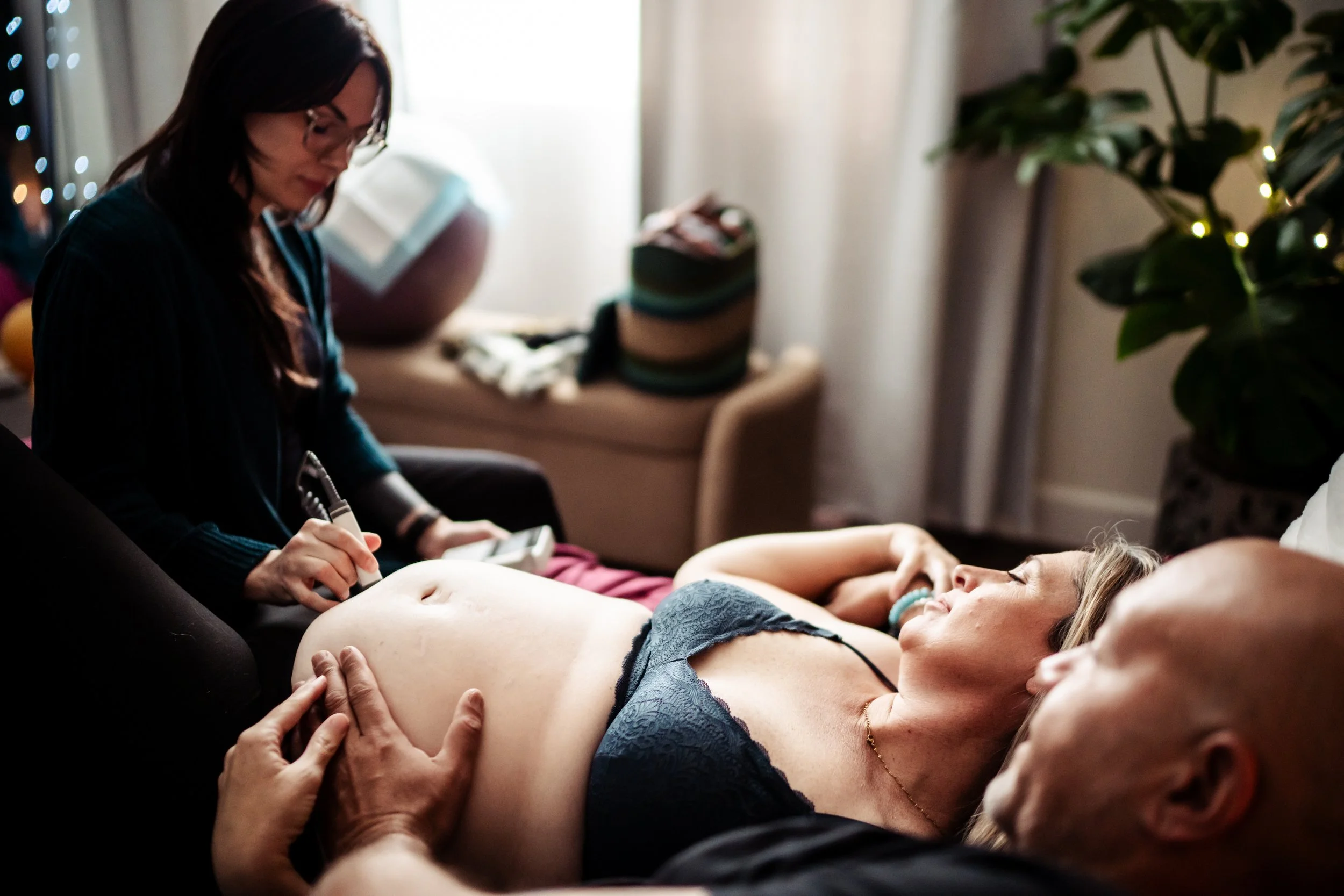Midwife supporting a laboring client during a home birth in Denver.
