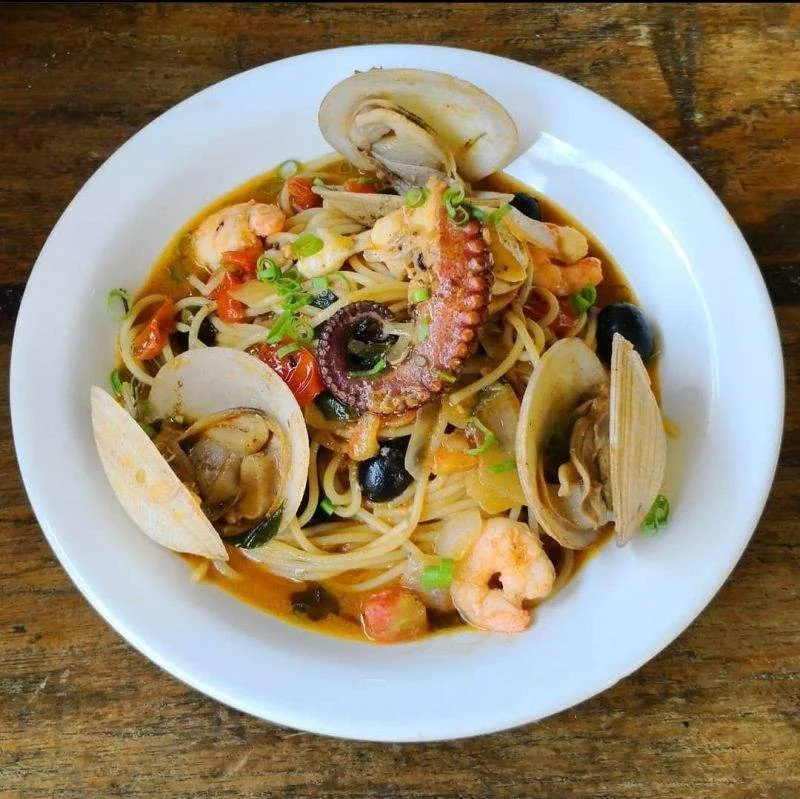Seafood pasta with clams, shrimp, octopus, olives, and fresh herbs.