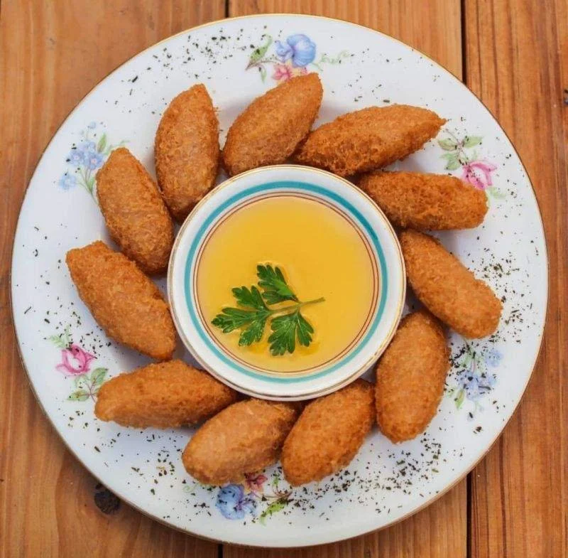Golden croquettes arranged around a dipping sauce.