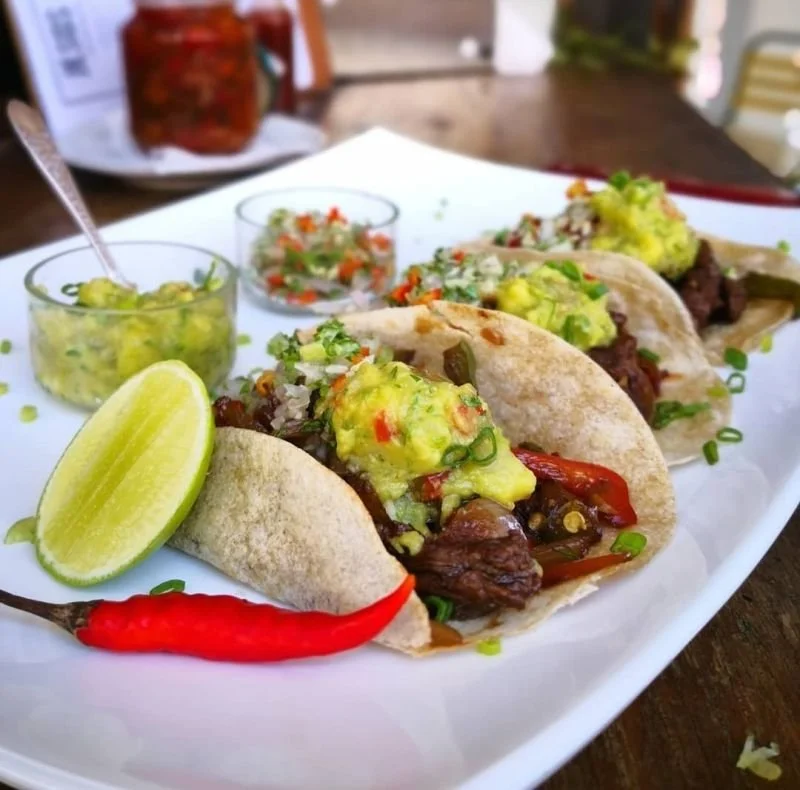 Tacos with guacamole, lime, and fresh salsa.