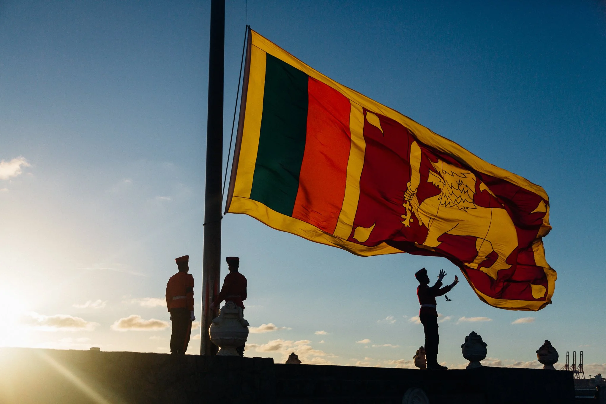 Sri Lankan military police lower the national flag at sunset on Galle Face in Colombo