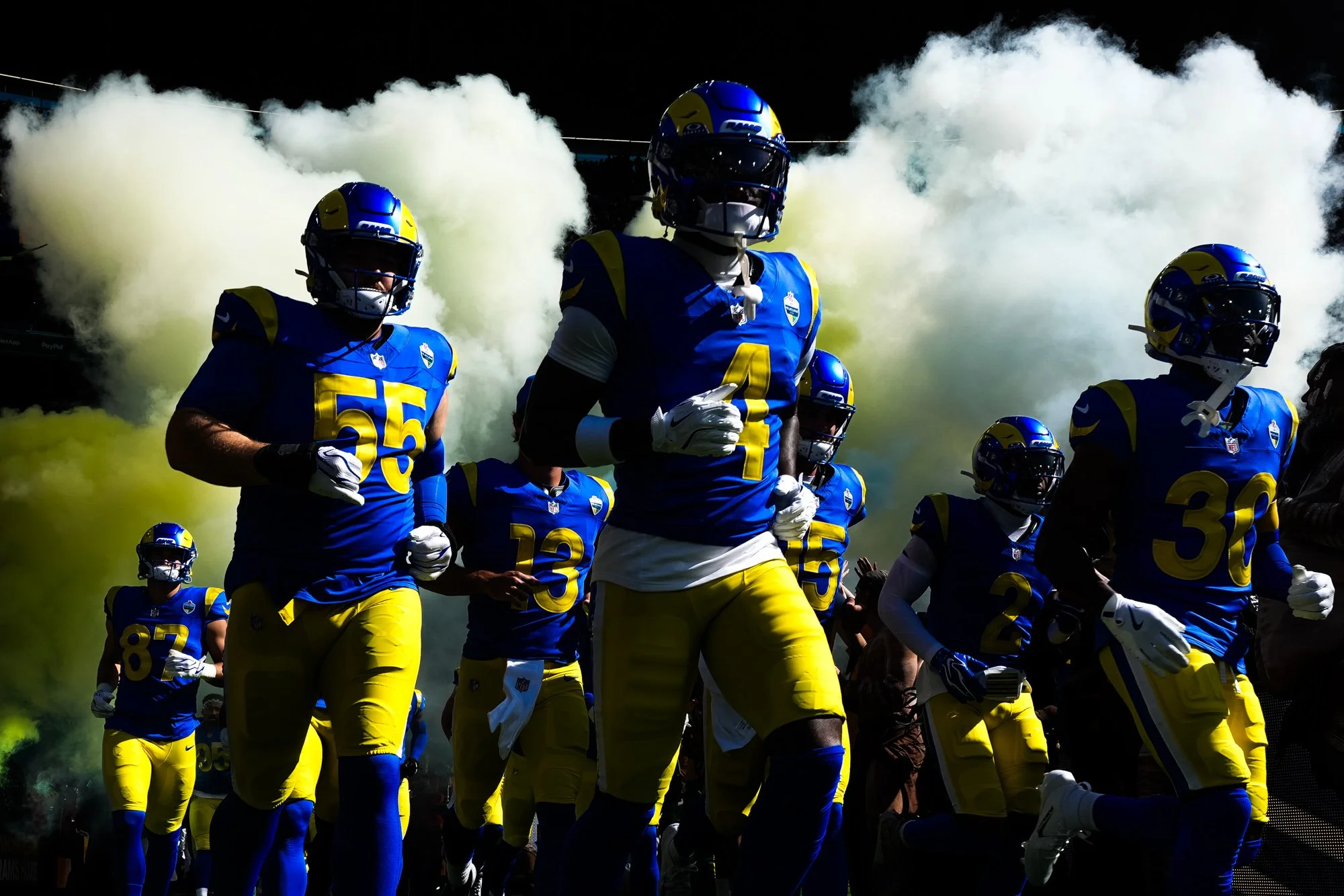 Los Angeles Rams players run onto the field through smoke before an NFL game at the Melbourne Cricket Ground in Melbourne.