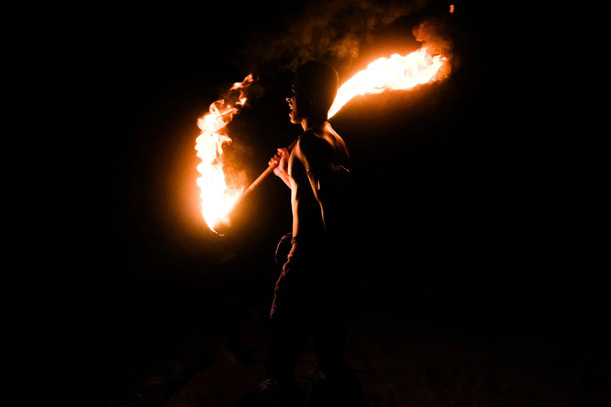 A Samoan fire twirler performs at night during a traditional show at Maninoa Villag