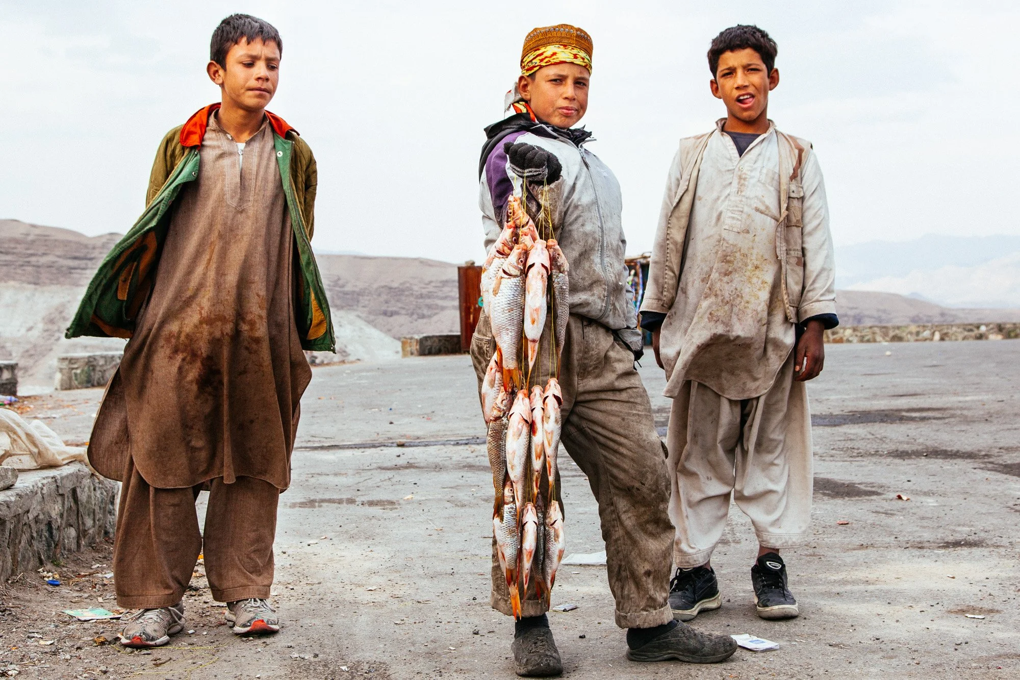 Young men sell fresh fish along the Kabul to Jalalabad road in Afghanistan.