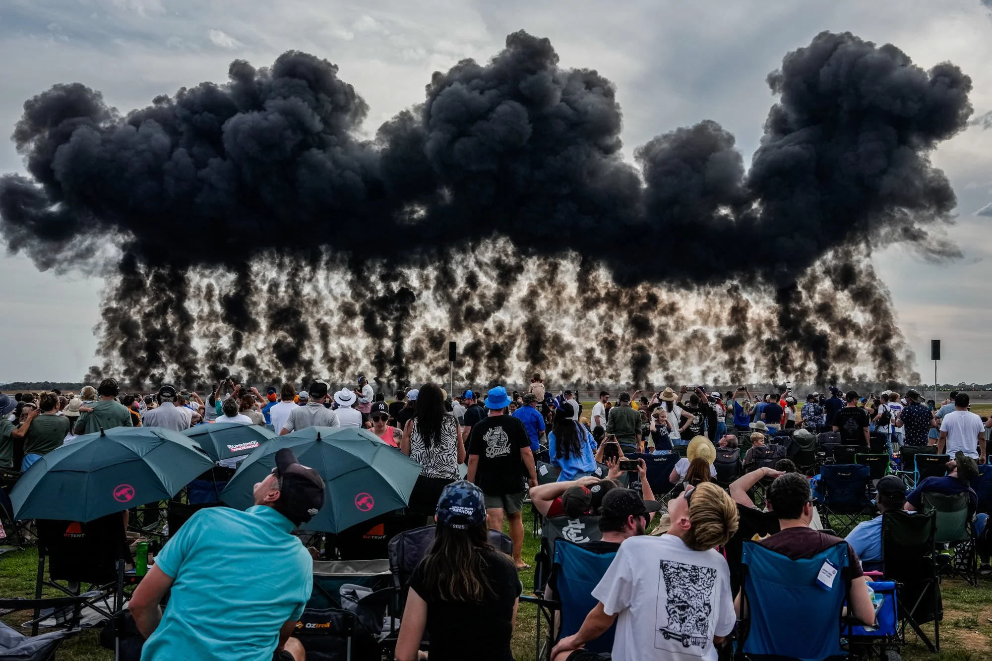 Spectators watch smoke rise from a wall of fire display at the Avalon Australian International Airshow.