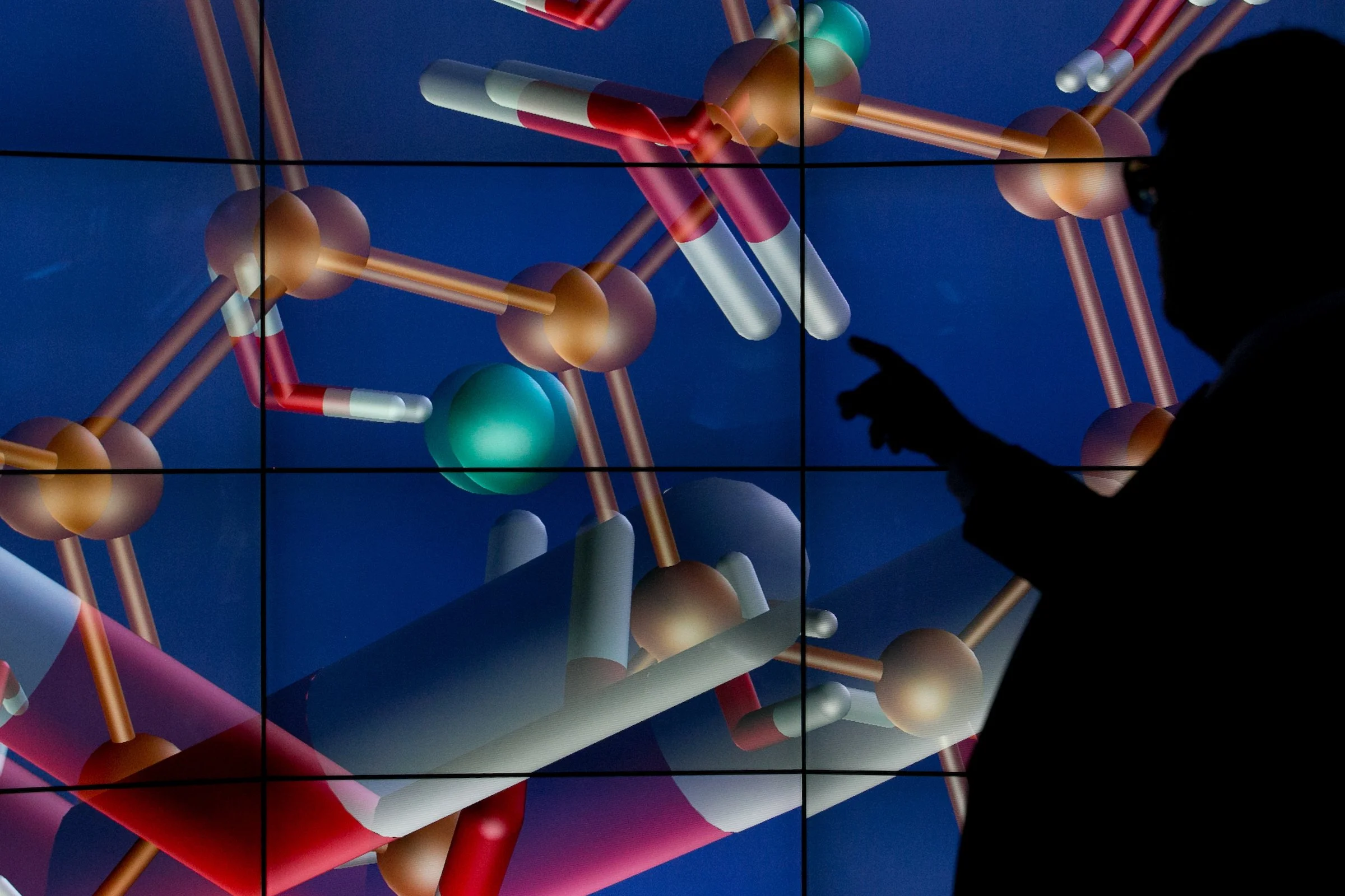 A molecular structure display is shown inside a university research facility.
