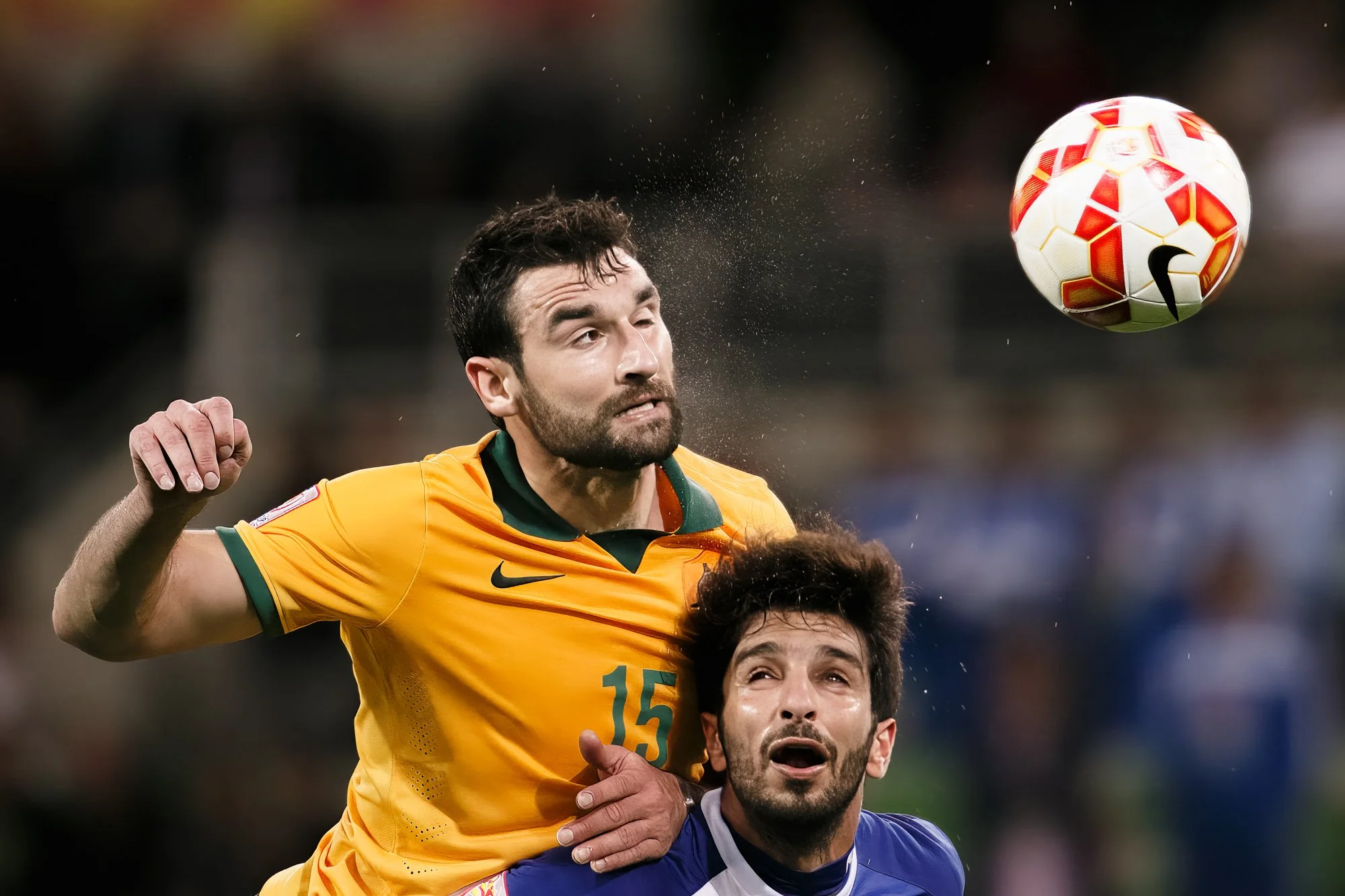 Mile Jedinak wins a header against Fahed Al Ebrahim during Australia v Kuwait at the 2015 AFC Asian Cup in Melbourne.
